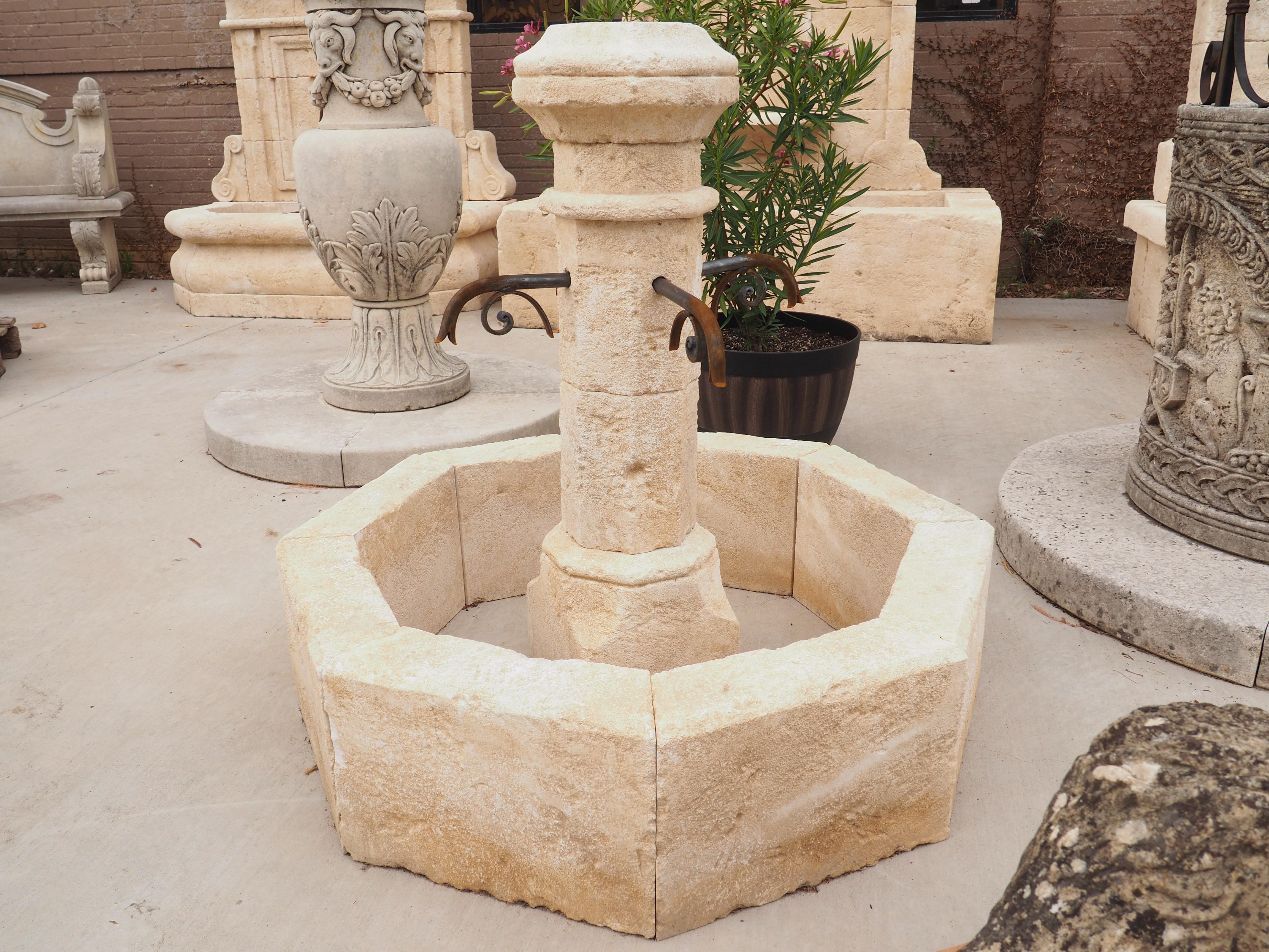 This wonderfully hand carved limestone, small centre fountain from France is octagonal in shape. It has four iron spouts that adorn the centre post. Always used as center fountains in villages throughout the ages in France, they are a beautiful