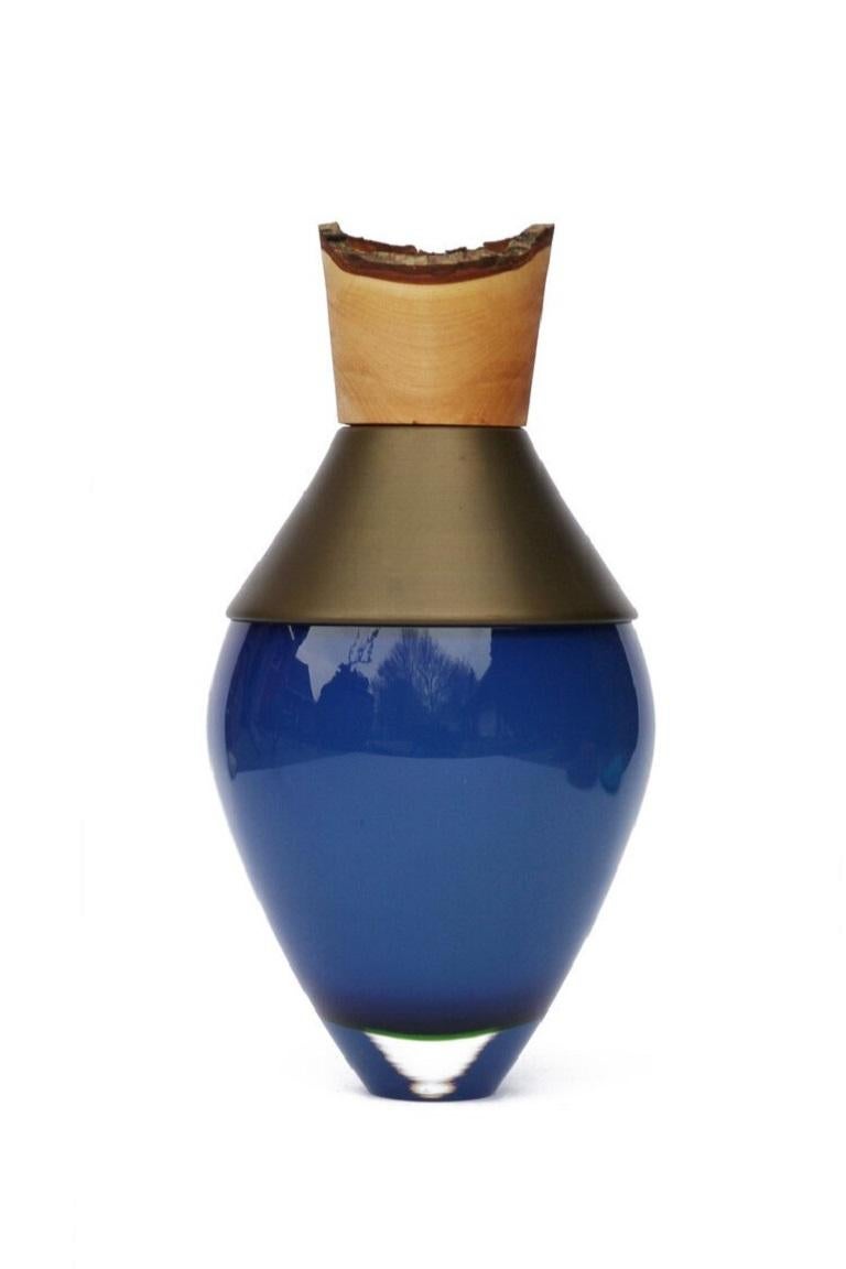 Small opal blue and brass patina India vessel I, Pia Wüstenberg
Dimensions: D 15 x H 30
Materials: glass, wood, brass patina
Available in other metals: brass, copper, brass patina, copper patina, rust

Handmade in Europe, by individual
