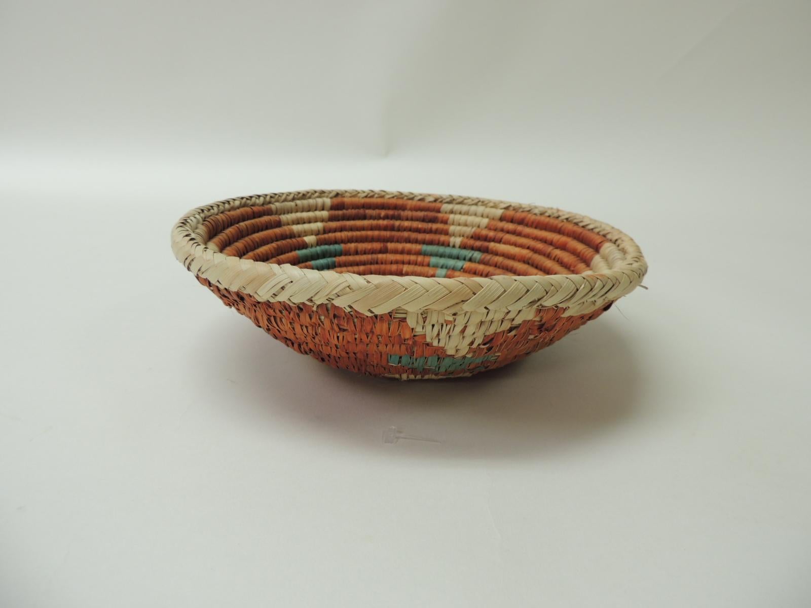 Small round tribal rustic decorative basket/bowl.
Handwoven artisanal round basket in shades of green, orange and natural.
Size: 3 H x 8.5 D.