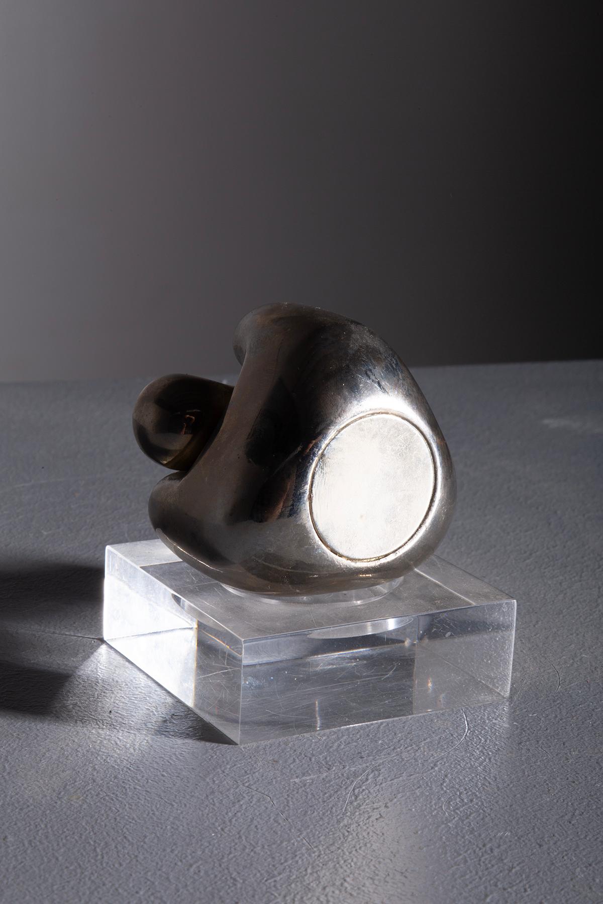 This sculpture dates back to the 1960s and is made of chrome-plated metal, perfectly capturing the design and creativity of that era. Its soft and fluid forms, characterized by rounded volumes and shiny surfaces, reflect the spirit of mid-century