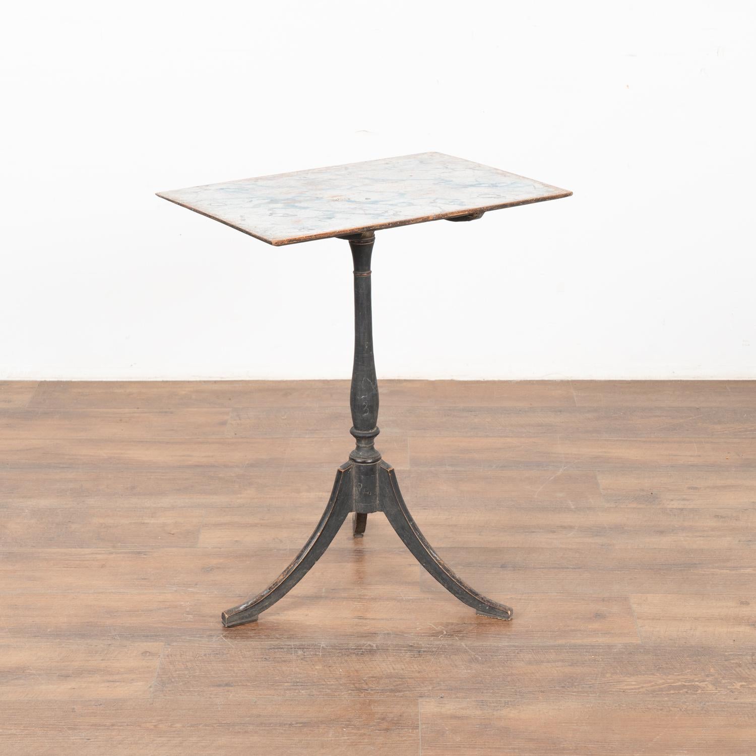 The original black painted base accentuates the simple grace of this pine tilt top side table with contrasting traditional faux marble painted top with touches of blue. Please enlarge photos to appreciate the lovely hand painted details of this