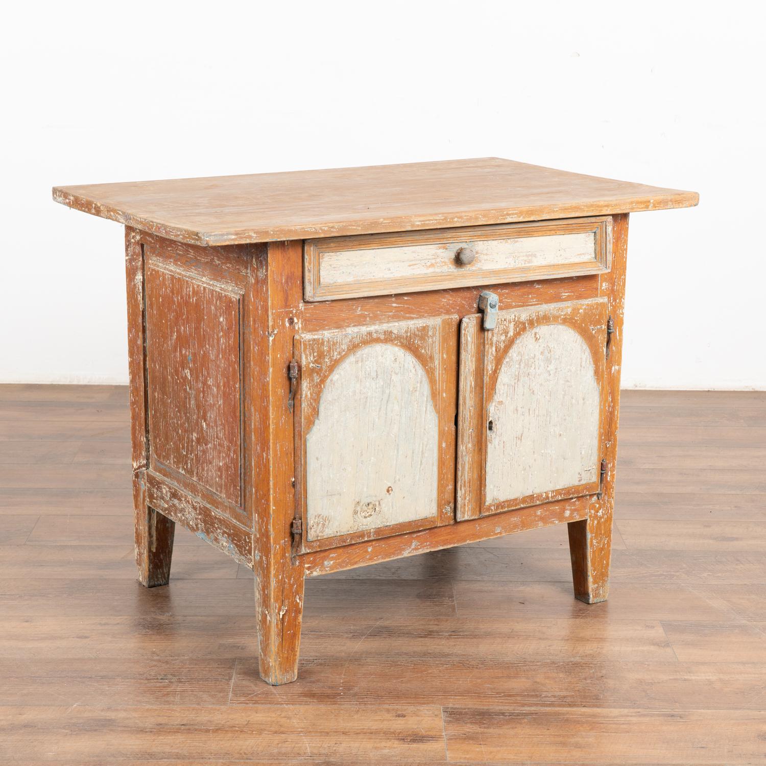 Antique Swedish country pine cabinet or small sideboard with single drawer over two doors.
The original brown and white painted finish reveals traces of blue, and has been distressed over many generations revealing the warm, natural pine patina