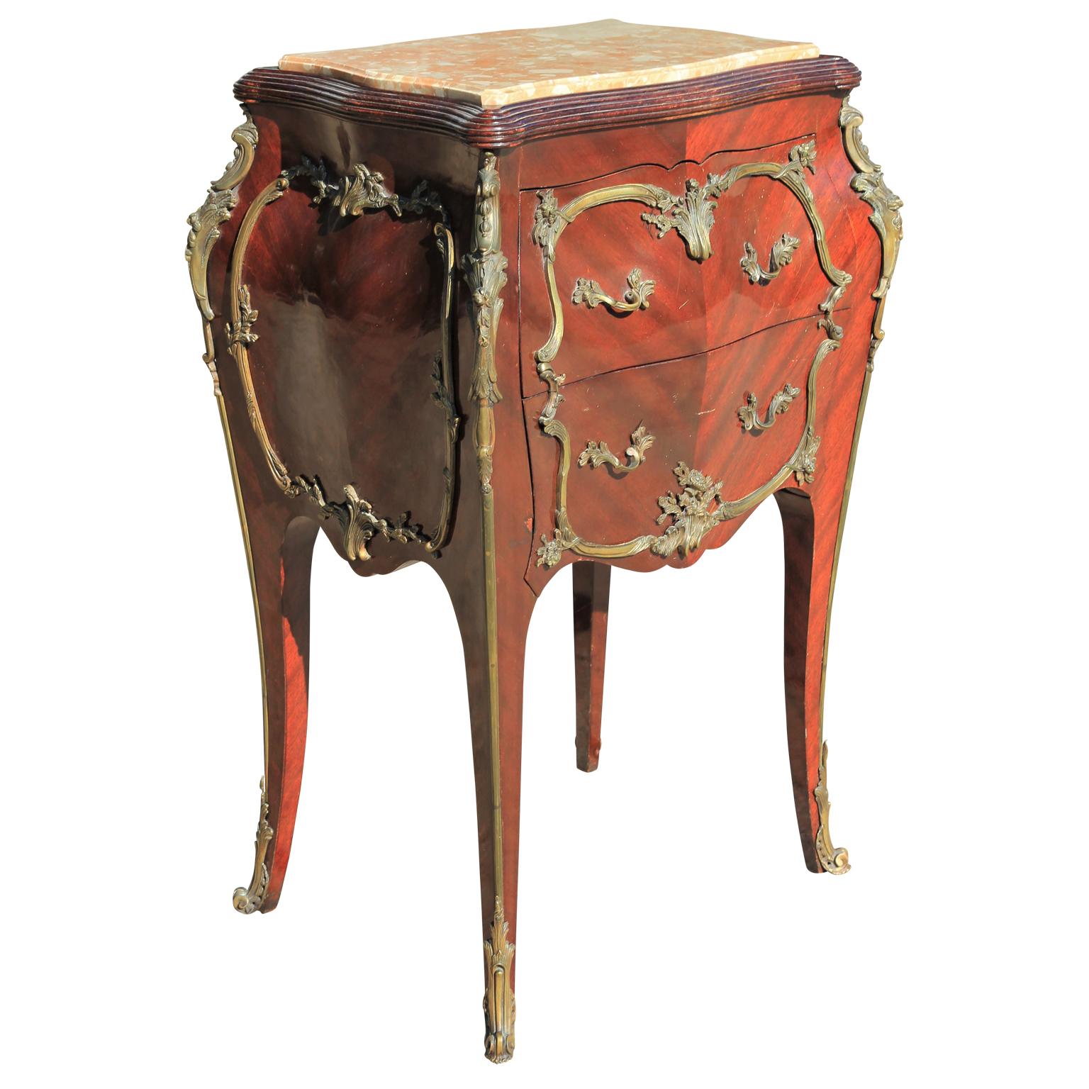 Lovely Bombé French Louis VXI style chest mounted in ornate bronze ormolu. Beautiful satin cut grain bookmatched, circa 1920s-1940s with a nice rose colored marble.