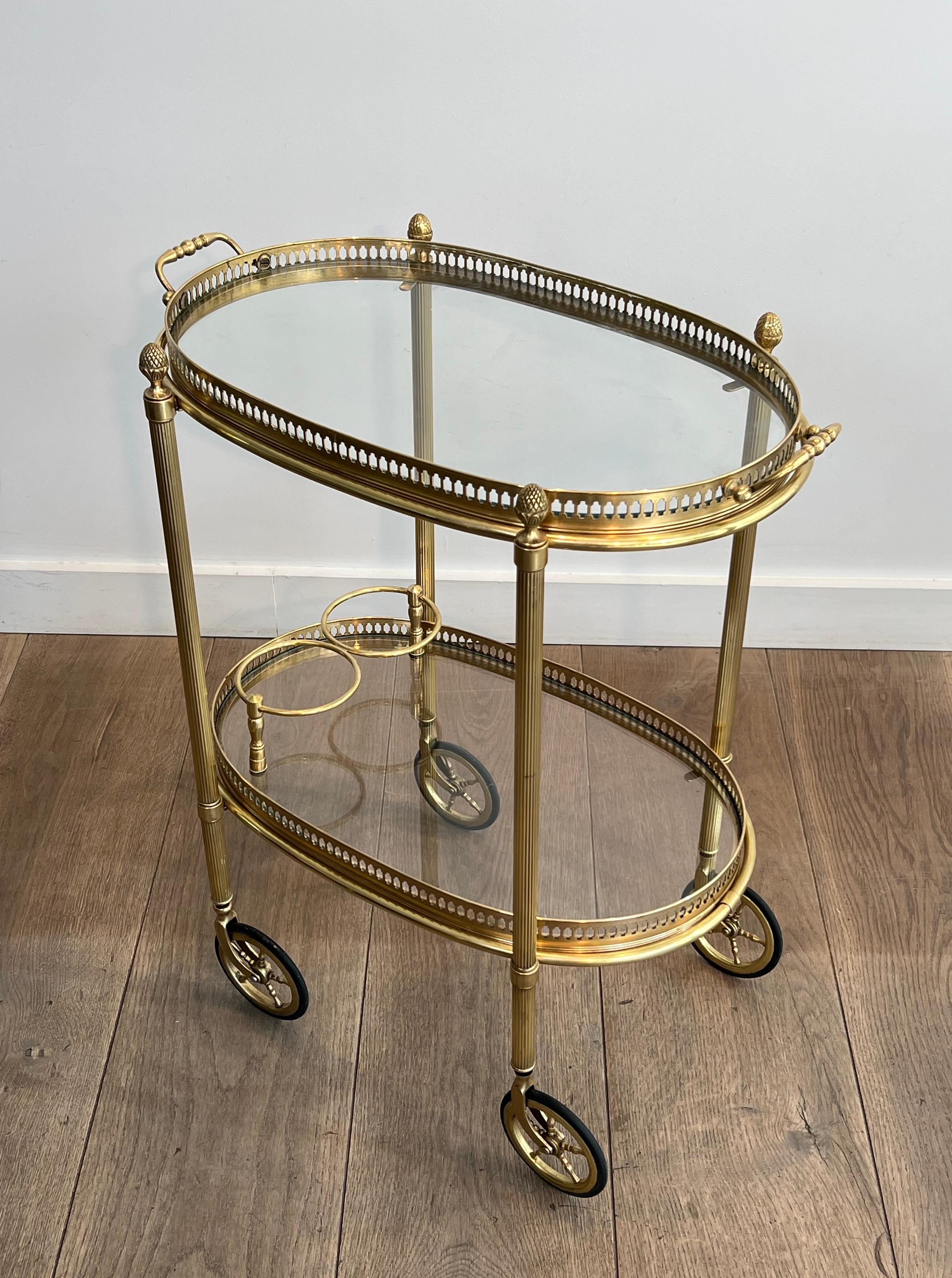 Questo piccolo carrello da bar ovale in stile neoclassico è realizzato in ottone.  con due piani rimovibili circondati da una galleria traforata. Questa è un'opera francese di Maison Bagués. Circa 1940