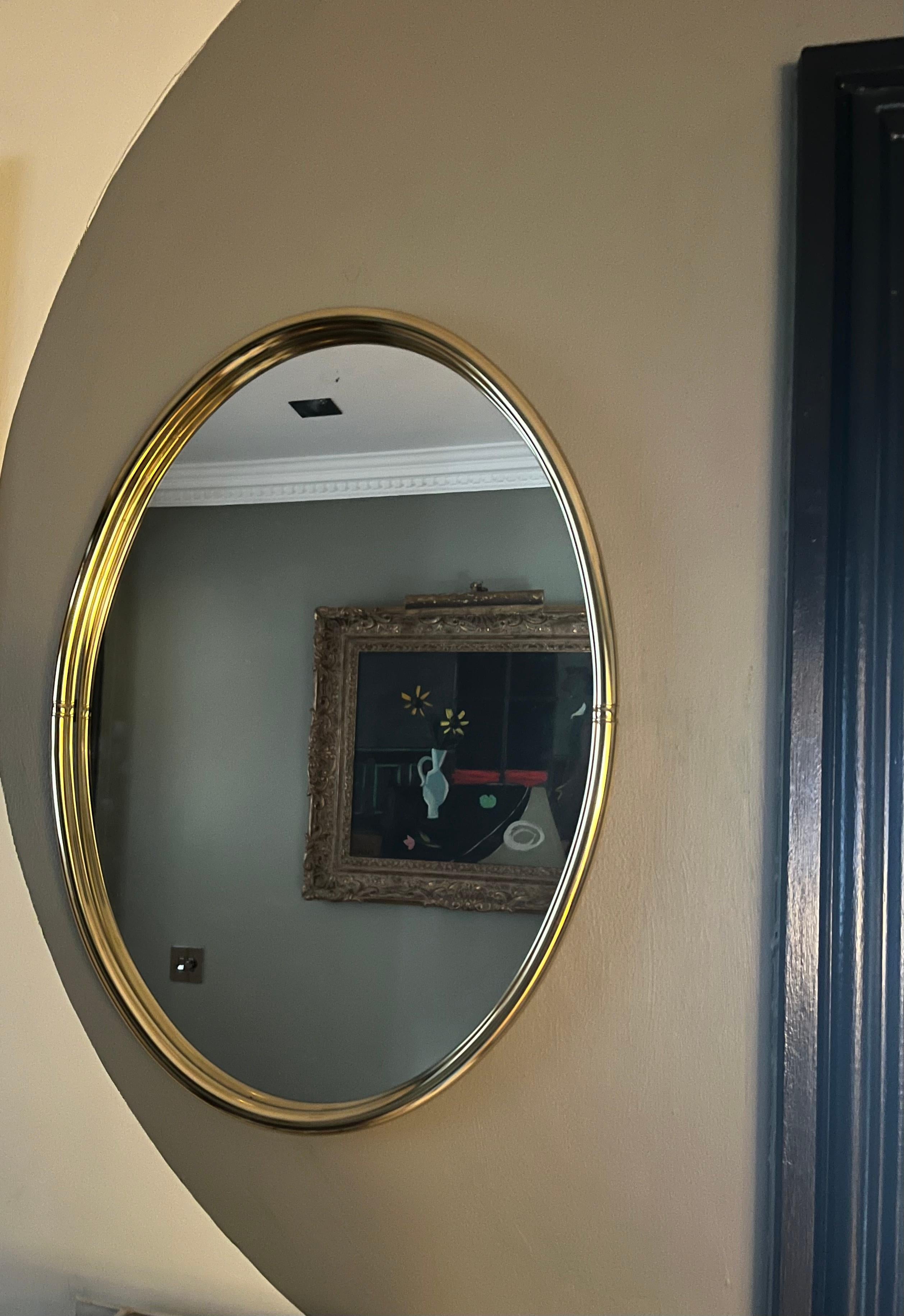 Joli miroir italien à cadre ovale en laiton patiné. 