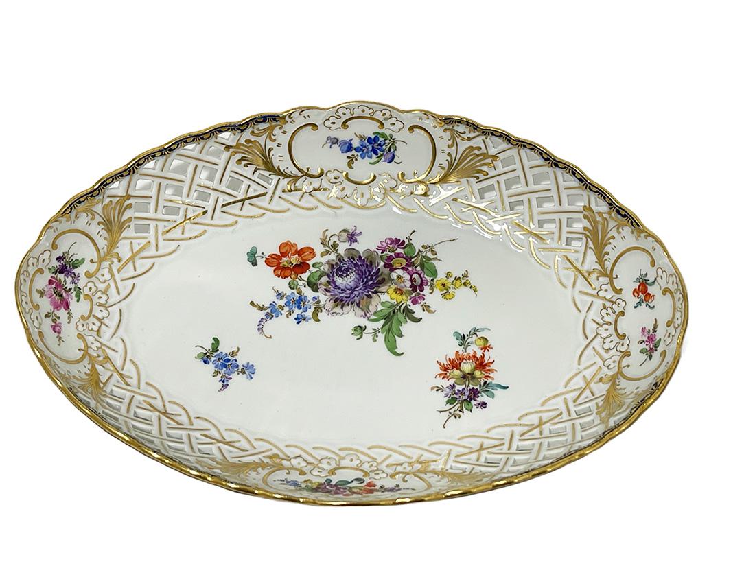 Small oval Meissen porcelain openwork dish, 1920s

An oval small dish by Meissen. An openwork porcelain dish with floral pattern. The rim is openwork porcelain and has 4 in cartouche painted gold, 4 different floral decoration. Between the