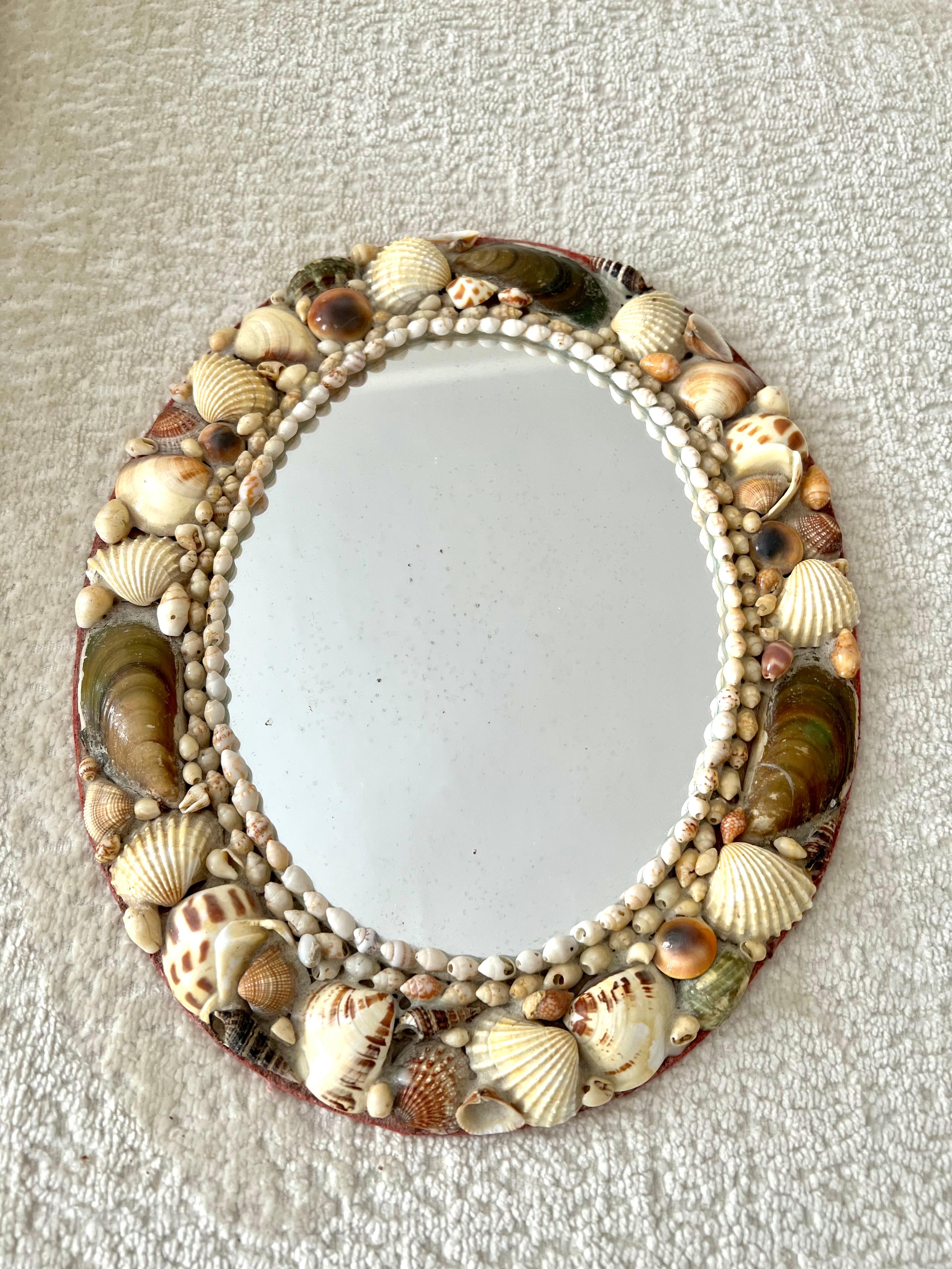 A small shell encrusted frame - a vintage and folk art piece with a red felt back. The piece is lovely for a bathroom, or dressing area - also would work well on any wall that wants a bit of diversity or is near the water.

A compliment to many