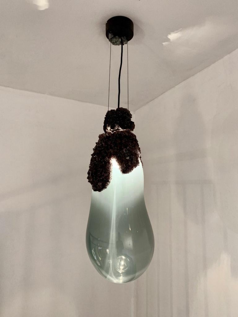 Small overgrown bubbles by Mark Sturkenboom and Alex de Witte.
Dimensions: D 21 x H 60 cm 
Material: Mouthblown glass, natural grown crystal, dimmable led, Colour White or grey black
Ceiling ornaments can be produced in crystal to extend the