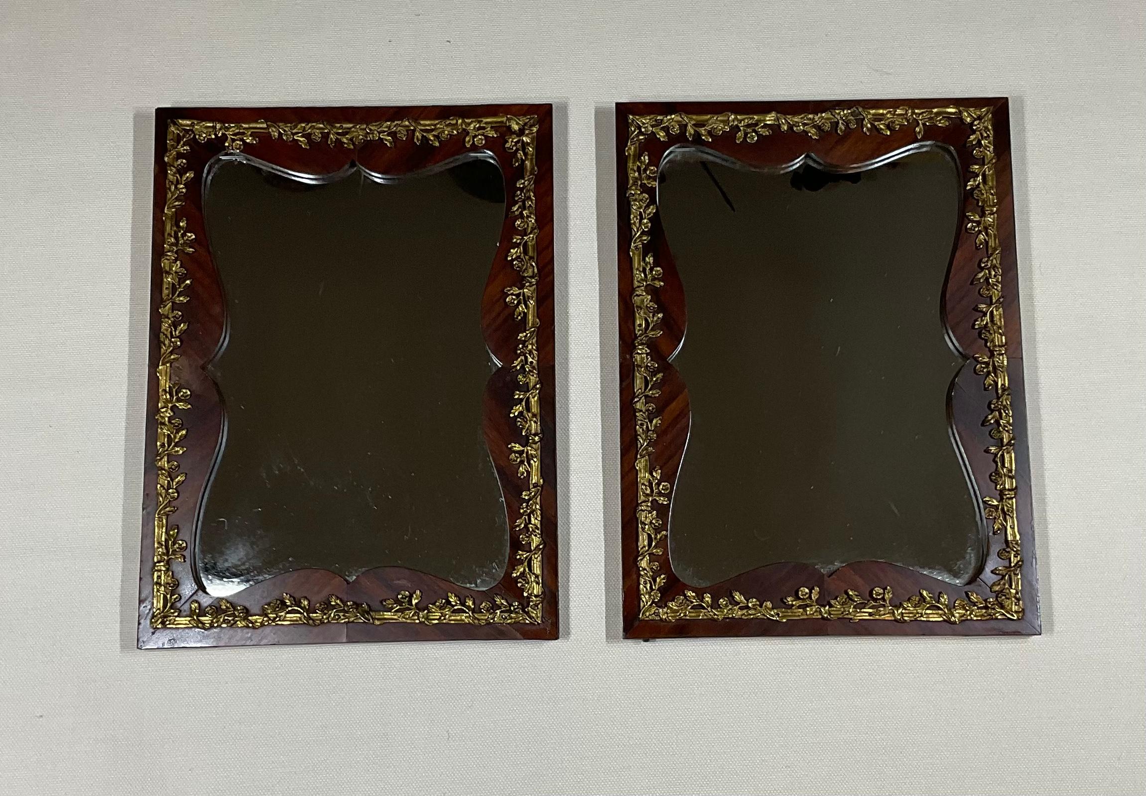 Belle paire de petits miroirs funky en bois massif avec revêtement en placage et garniture exceptionnelle en bronze. Cette paire de miroirs était à l'origine des portes d'une vitrine à bijoux française qui a été récupérée et convertie