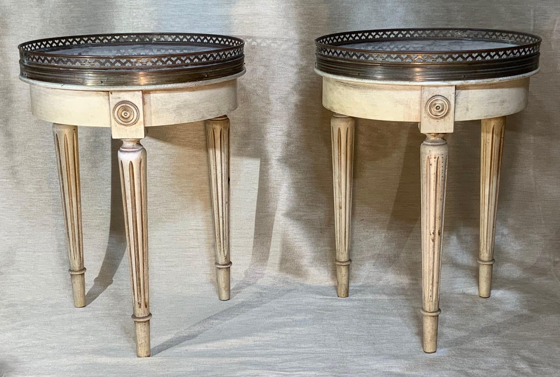 Elegant pair of vintage side tables made of three legs carved wood, white -gray marble top surrounded with decorative Brass trimming.