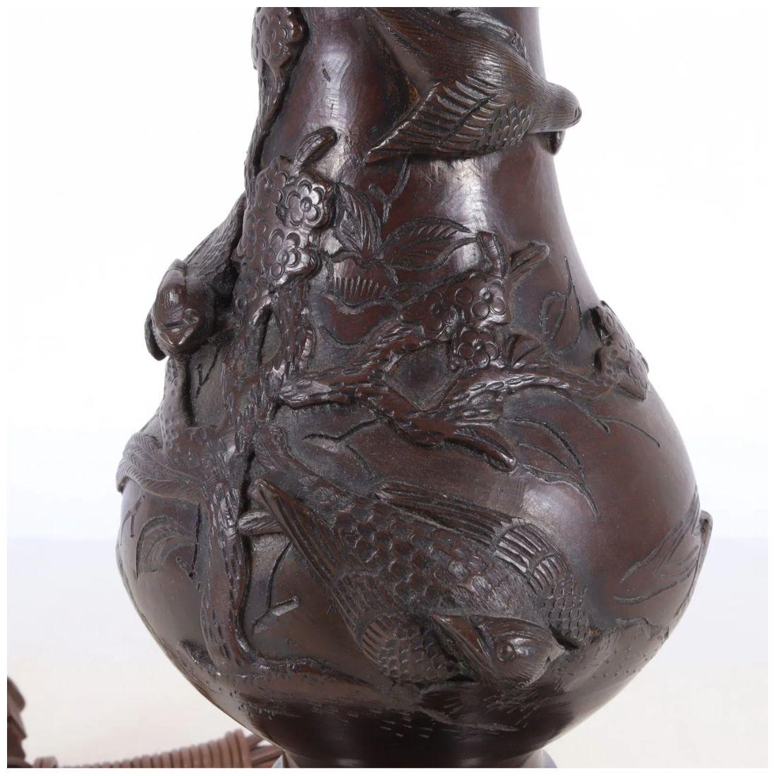 Affascinante e piena di carattere, questa piccola lampada in metallo patinato presenta un'elegante decorazione in stile cineseria con uccelli e rami che circondano il corpo. I dettagli intricati aggiungono consistenza e interesse visivo, mentre la