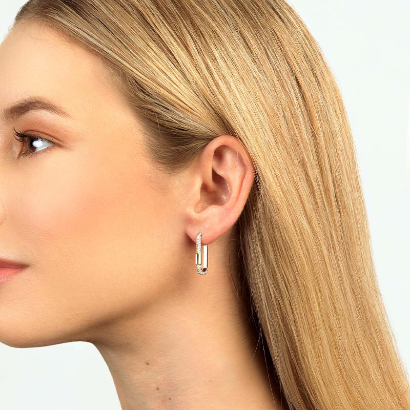 This classic huggie hoop has been given a modern edge with our lock design.

Crafted in solid 18k gold, this earring is partially encrusted with pave diamonds and is finished with a solid gold barrel. A unique style, this earring will perfectly