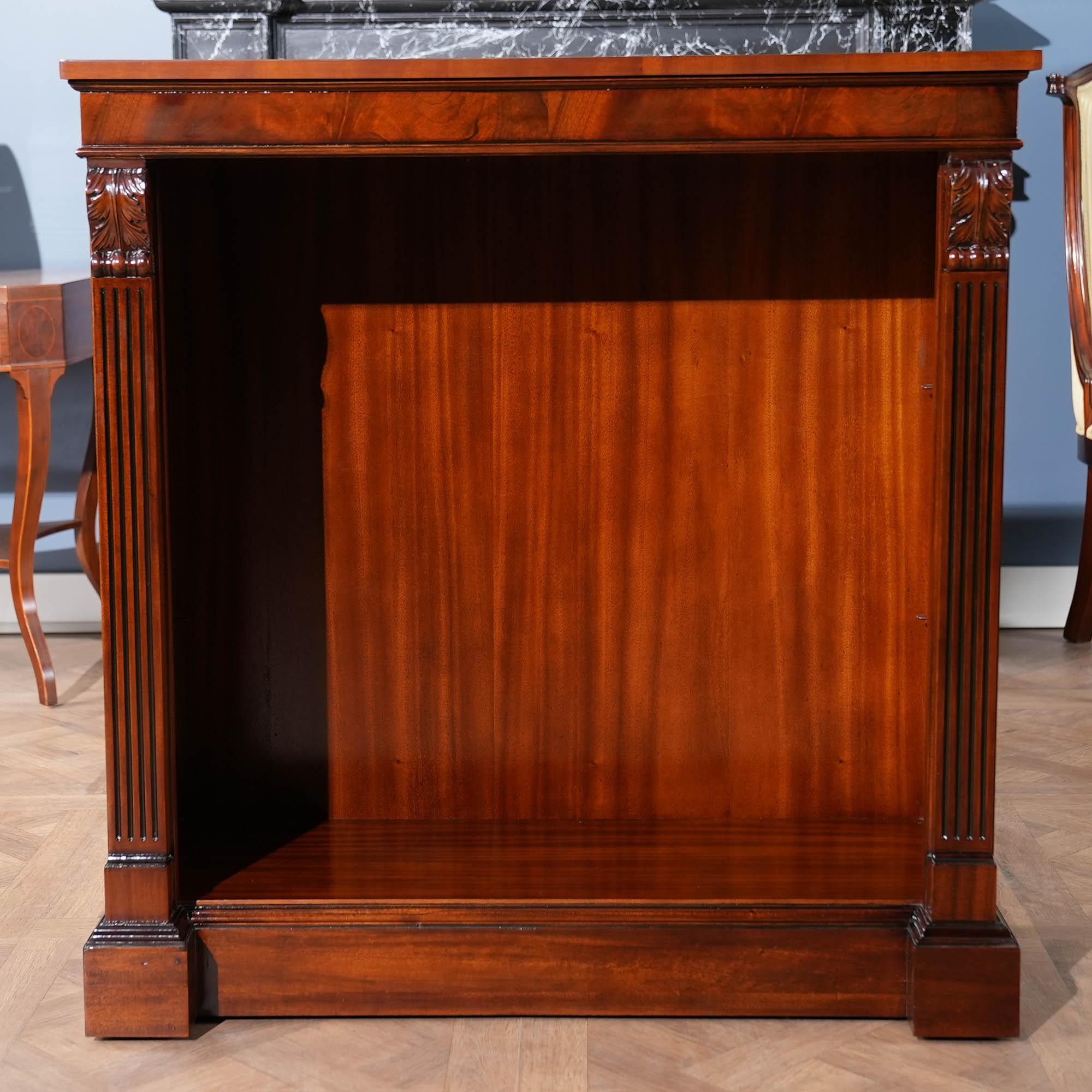 This is Niagara Furnitures’ Small Penhurst Mahogany Bookcase. The figural mahogany cornice is beautiful and adds a sense of depth to the upper area of the case while hand carved acanthus, solid mahogany brackets and reeded columns lend a sense of