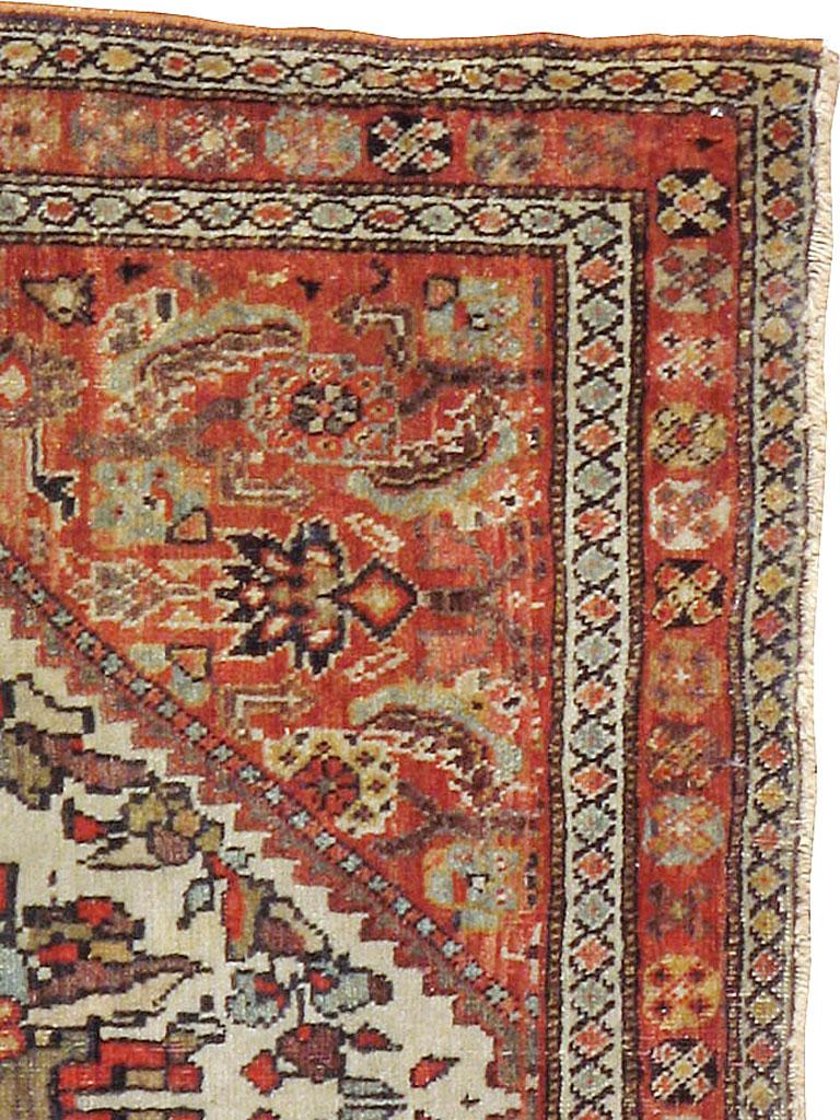 An antique Persian Fereghan rug from the late 19th century. A giant stepped ivory diamond medallion encloses a detailed complex palmette and encircling floral wreath and is set on a rust Herati field. An X-in-octagon main border and two ivory minors
