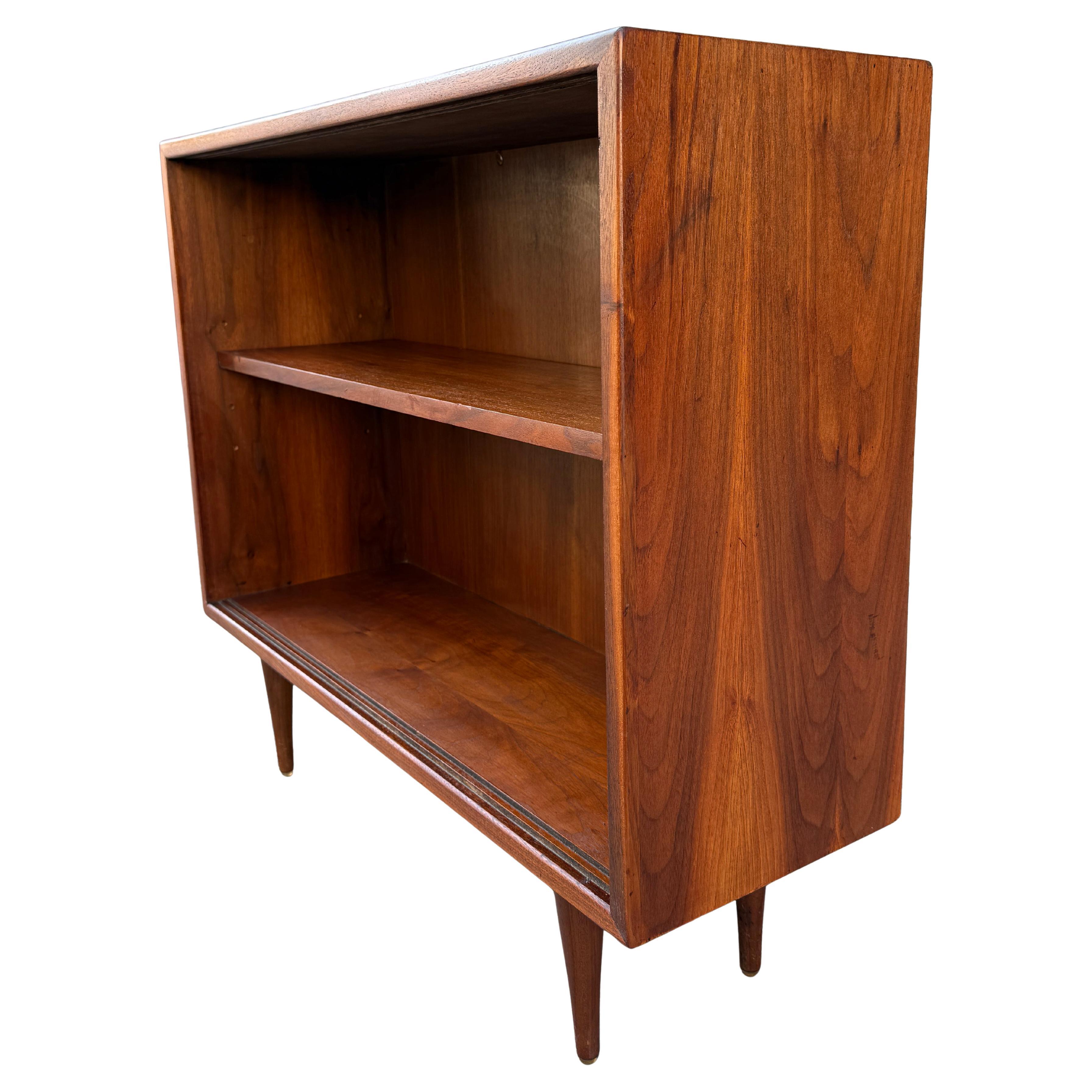 Belle proporzioni nella libreria in noce su gambe affusolate con finitura originale e bella patina. Can ha porte scorrevoli in vetro che possono essere rimosse. Altezza interna 21