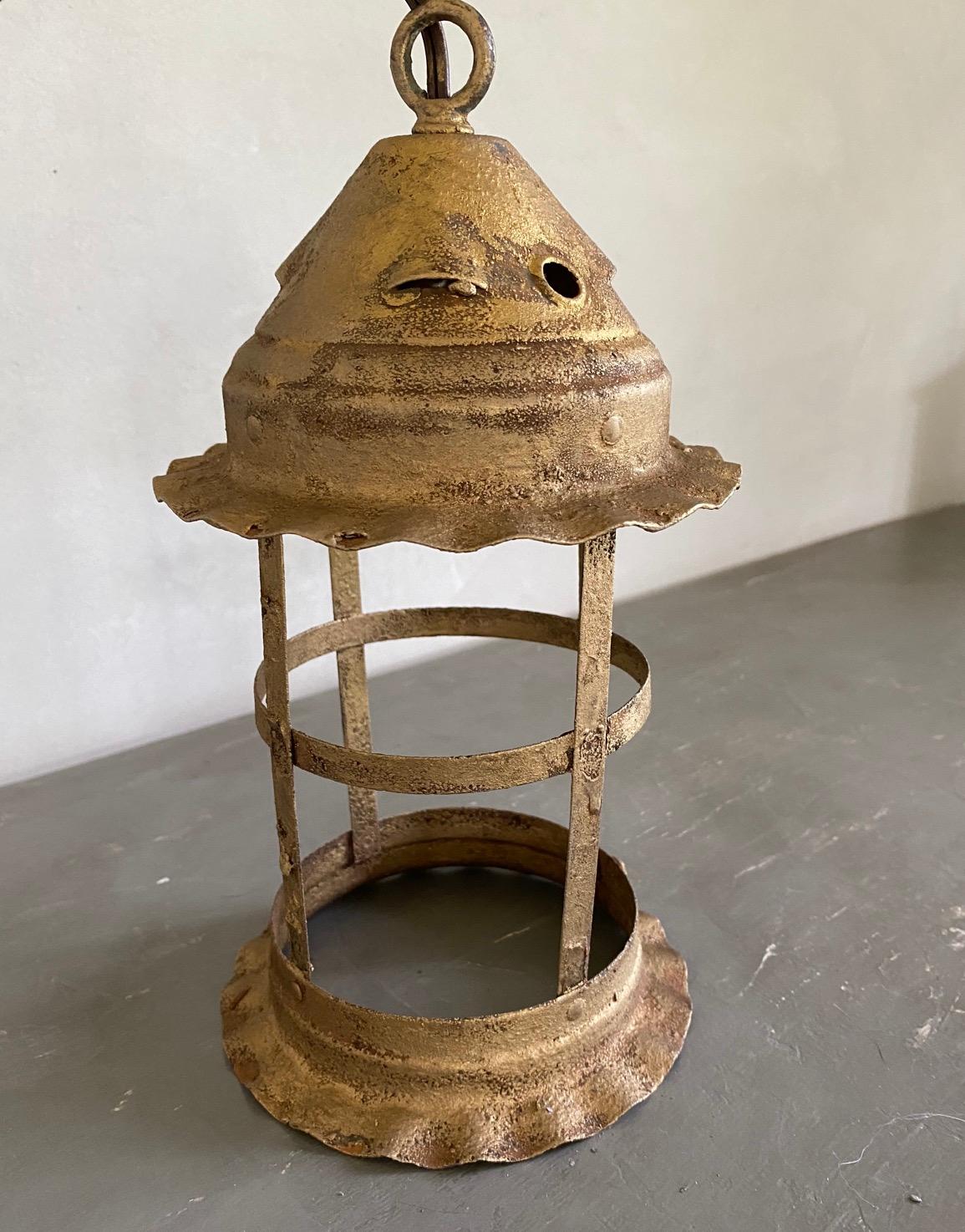 Small rustic vintage iron lantern with gold gilt finish. Wonderful antiqued patina. Hard to find small size for powder room hallway or small area. Newly rewired. Hanging pendant lighting.