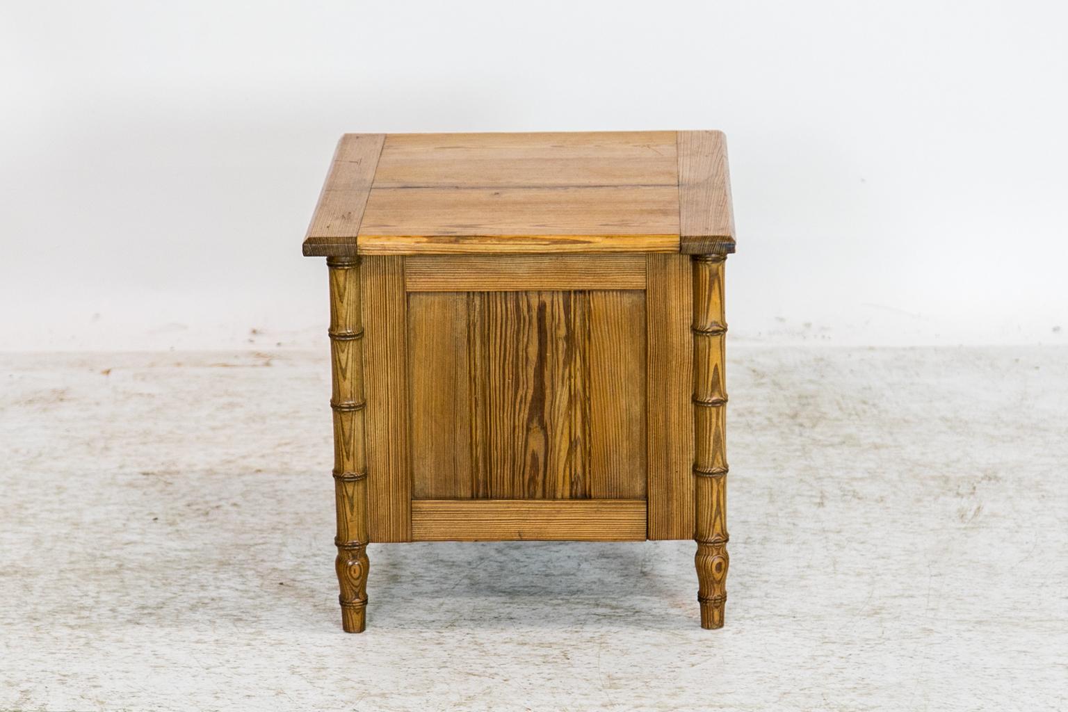The front legs of this pine commode are turned in a faux bamboo motif. The front has a recessed panel. The interior has been altered to remove the potty cupboard. The left side has a 1/8-inch shrinkage separation. The top has a one-inch separation