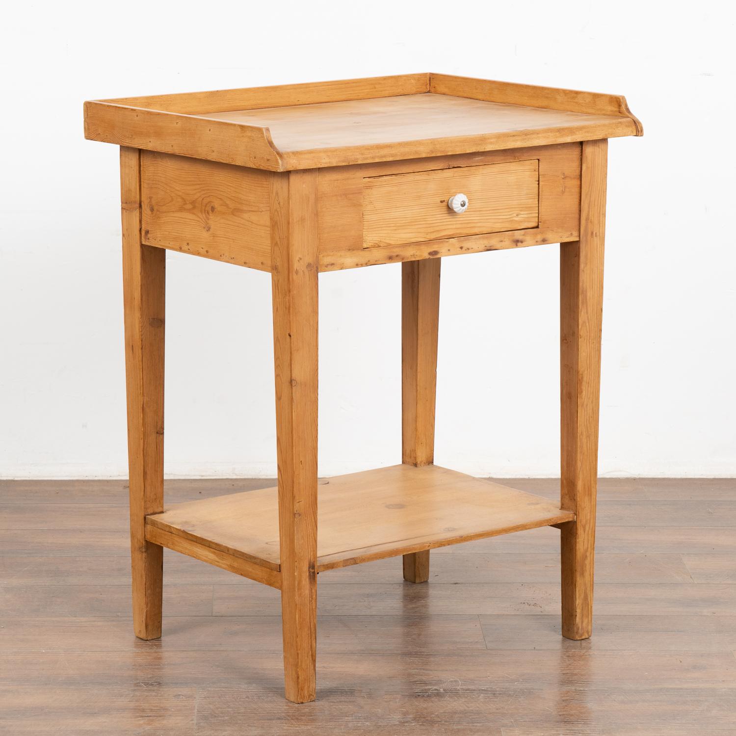 This delightful country pine table with single drawer and raised rim will make a casual side table or nightstand. 
This table has been restored, the drawer functions and it is ready to be used and enjoyed.
All scratches, cracks, dings, and age