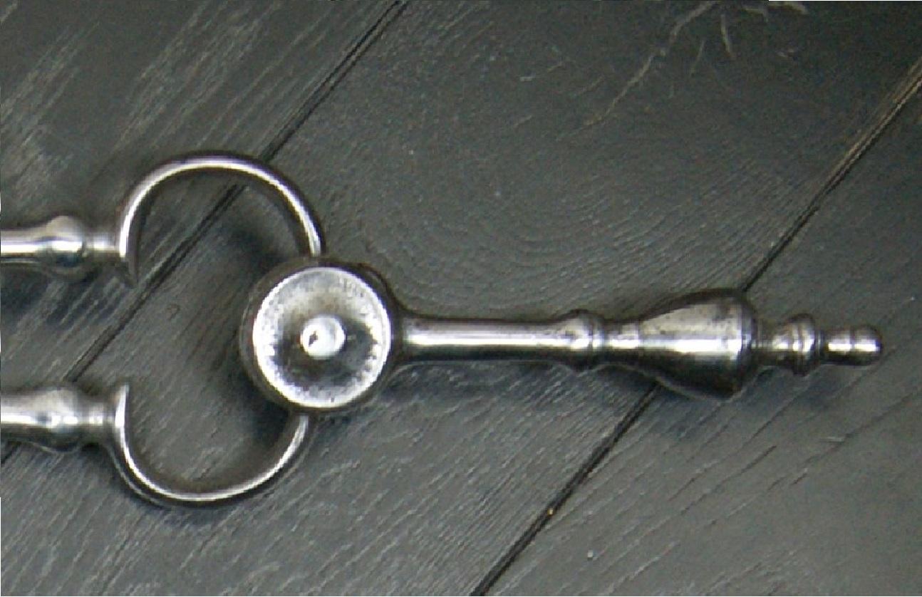 Un raffinato set di tre piccoli utensili da fuoco in acciaio lucido in stile georgiano, con dettagli a nodini sui fusti, manici con finali a urna e una padella forata.  Ripristinato.
Circa 1890