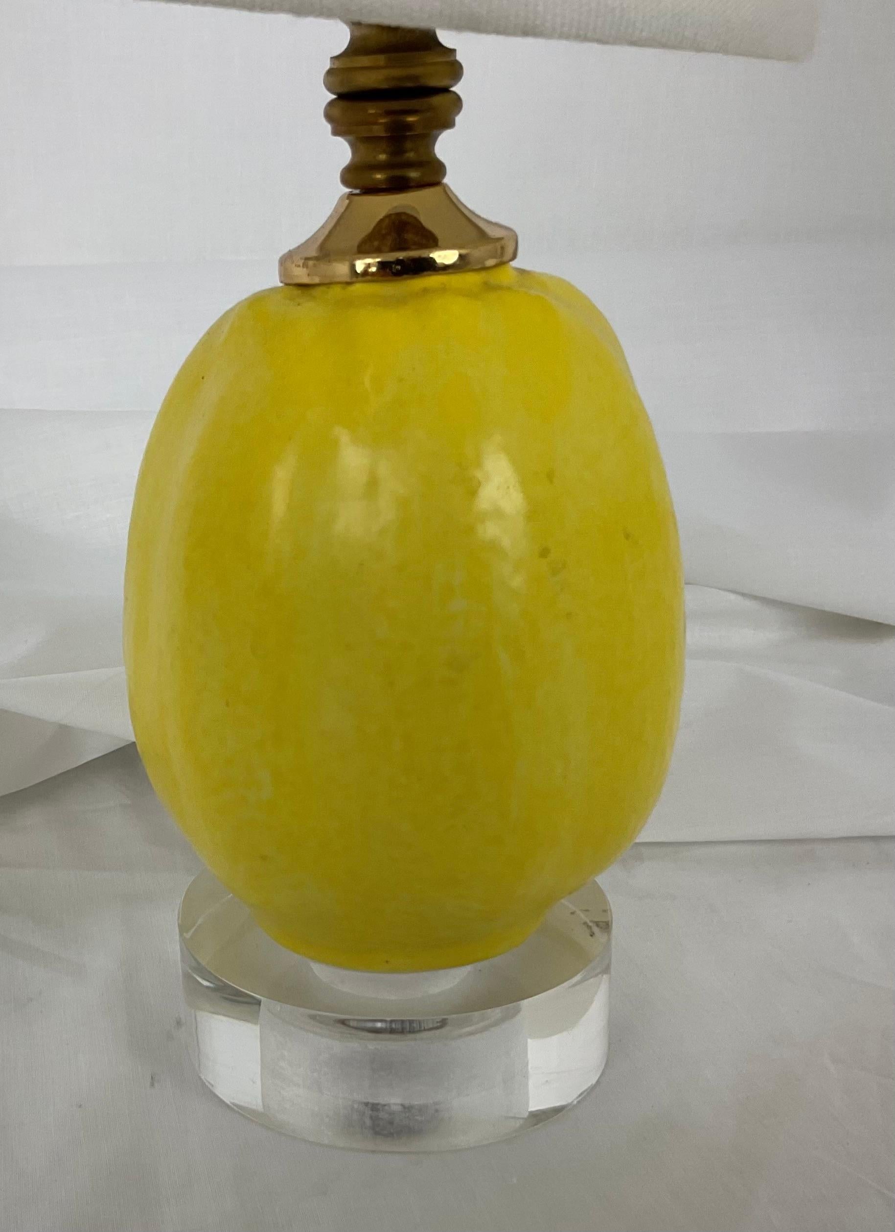Bright and stylish, this vintage mid-century table lamp features a bold yellow ribbed glass body mounted on a clear Lucite base. The vibrant color brings a cheerful pop to any interior, while the clean lines of the design to keep it versatile and