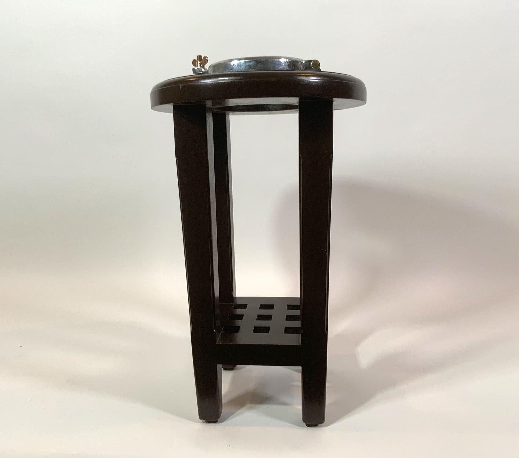 Hublot de bateau en aluminium transformé en table sur mesure. Hublot de bateau ancien qui a été fortement poli. Il est monté sur un socle en acajou à quatre pieds fuselés avec une étagère personnalisée.

Poids : 12 LBS
Dimensions globales :
Bois