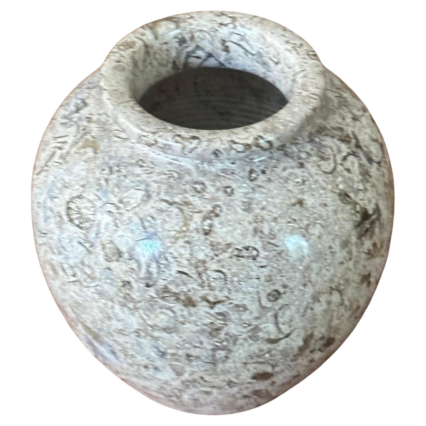Small post-modern fossilized stone vase, circa 1980s. The vase is primarily a cream color with black and grey veining throughout. The vase is in very good vintage condition with no chips or cracks and measures 4
