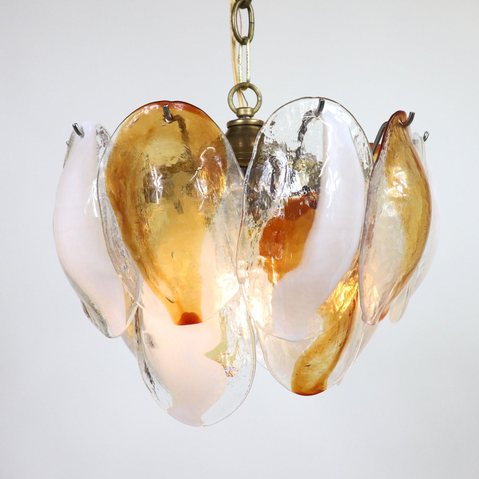Ce luminaire postmoderne en verre de Murano de La Murrina présente deux niveaux de coquilles en verre cristallo avec des bandes centrales ambrées et blanches. Chaque coquillage est un élément soufflé individuellement à la main, soigneusement placé