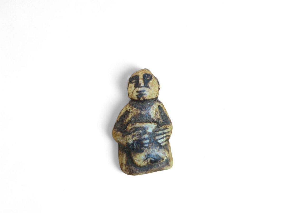 Eine ausdrucksstarke und fein geschnitzte pre-Columbianische Miniaturfigur, die nur 4 cm hoch ist, aber reich an symbolischem Charakter und Präsenz. Die aus Stein gefertigte Figur stellt eine stilisierte menschliche Form dar, die sitzt oder steht