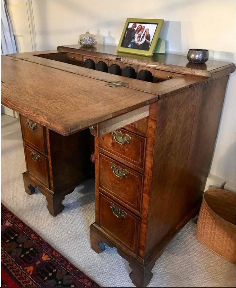 A rare, small, English early-18th century walnut kneehole desk. 
George II period, circa 1735.

This fine Georgian walnut kneehole desk is of a very rare form.
The hinged fold-over moulded bachelor’s top is supported on twin lopers, opening to