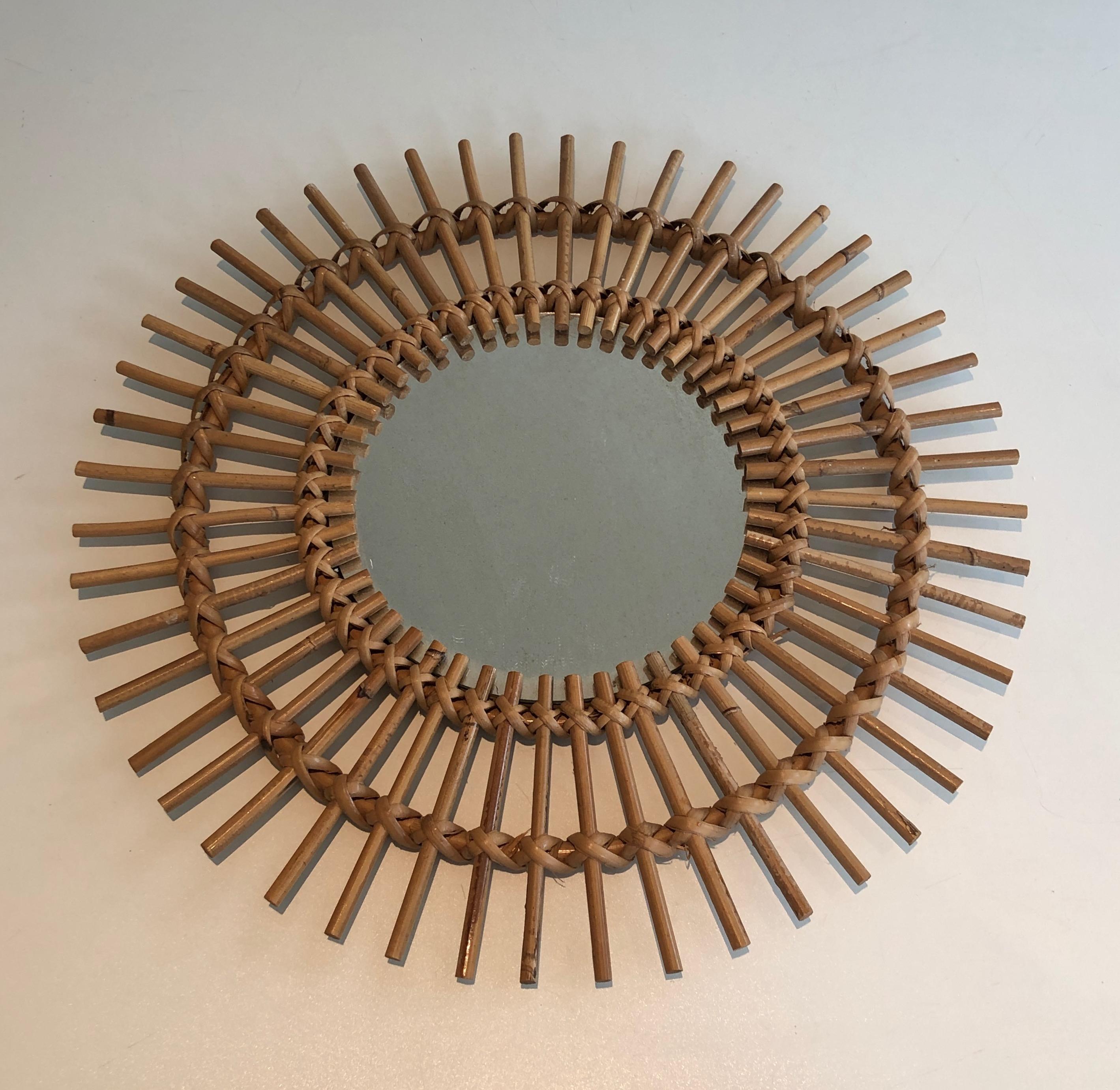 Questo specchietto rotondo è realizzato in rattan. Si tratta di un'opera francese del 1970 circa.