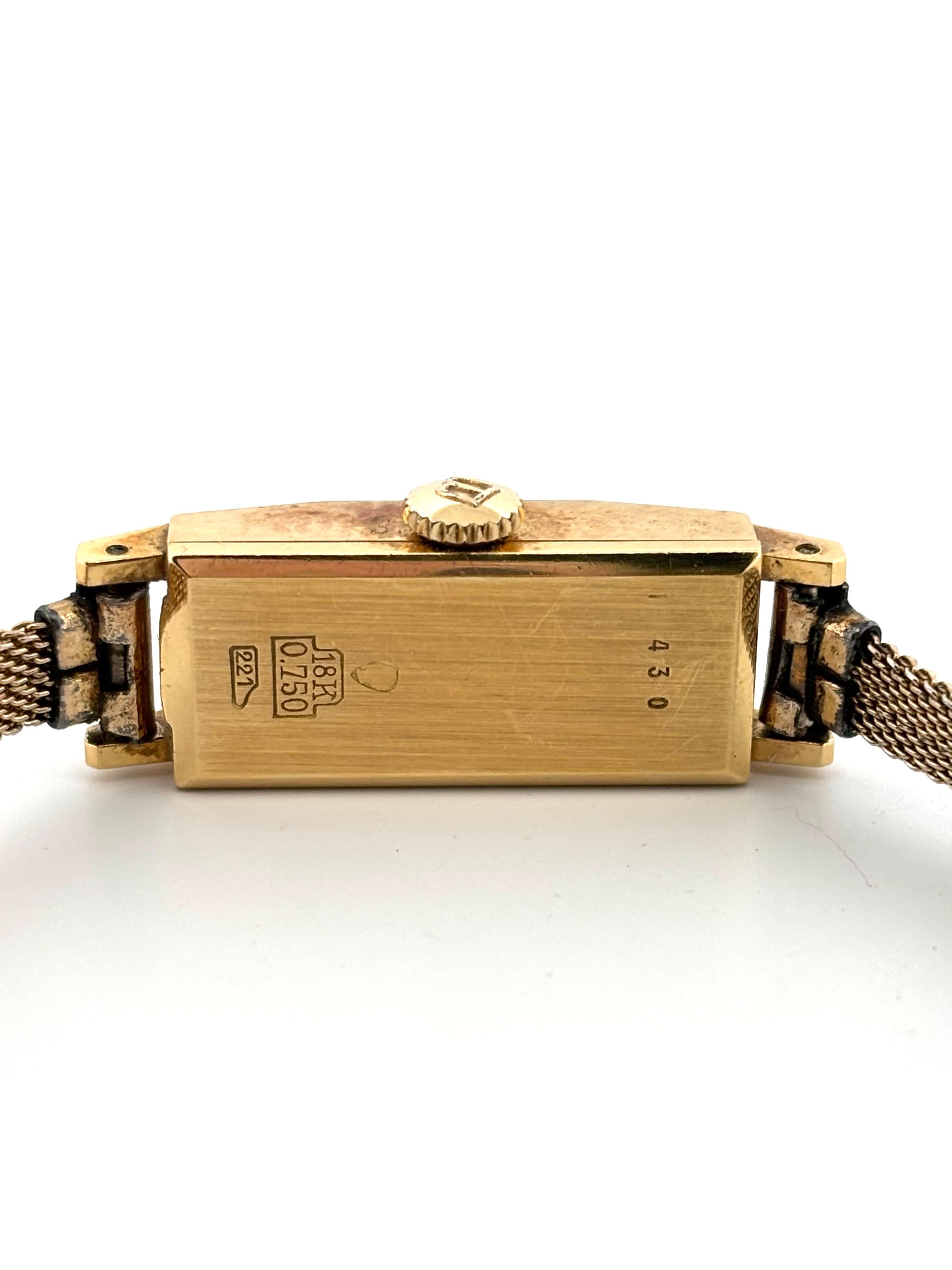 Cette élégante montre-bracelet vintage pour dames de Bucherer met en valeur le savoir-faire suisse intemporel dans un design raffiné et compact. Le boîtier rectangulaire, réalisé en or jaune massif 18 carats, mesure 23 mm de long sur 10,5 mm de
