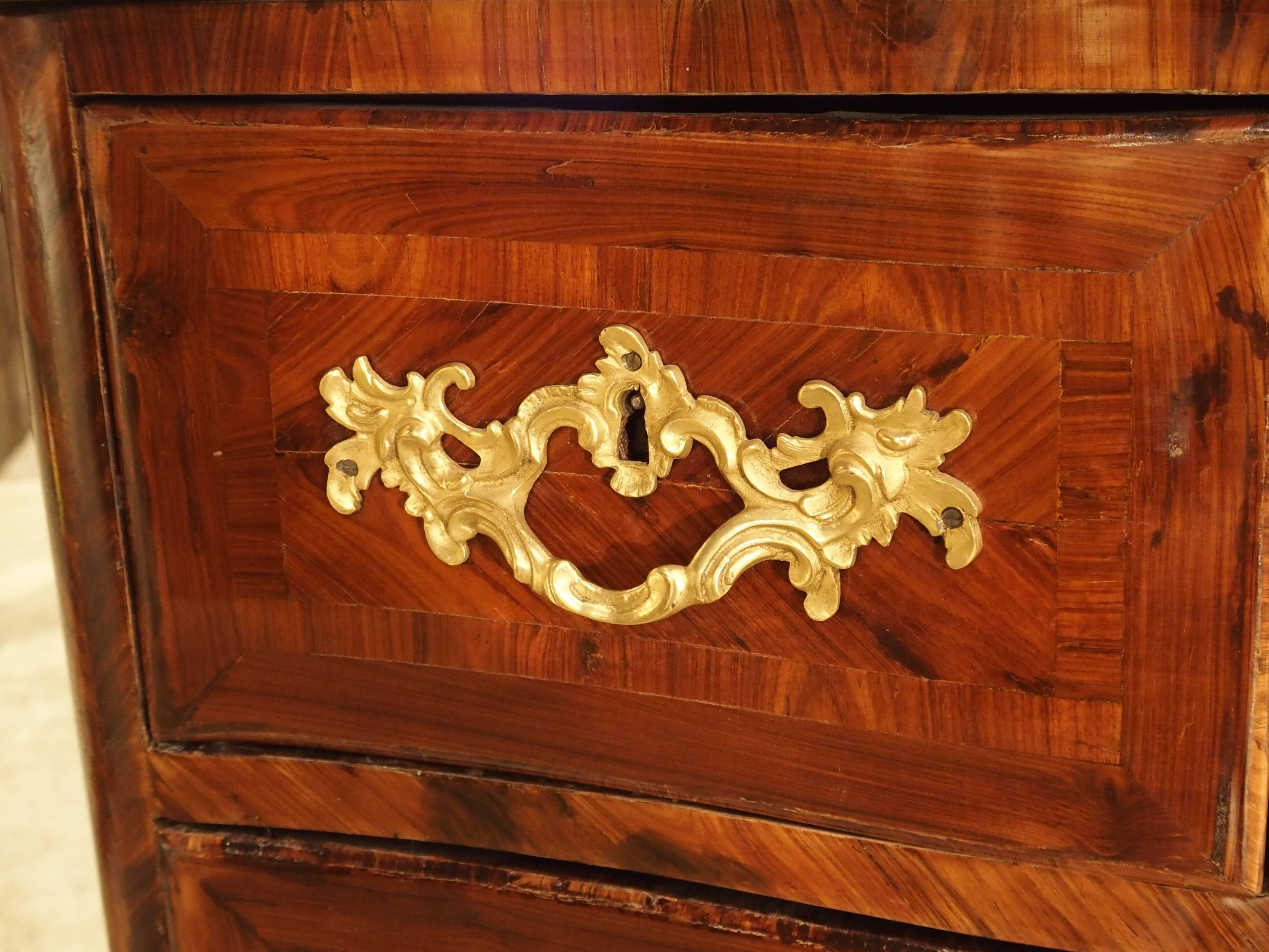 This rare French Regence period commode has been made with a kingswood veneer. The parquetry veneer on the sides is in a V-shape with the grain matching perfectly at the centre. It is placed within a rectangular frame of parquetry veneered sections.