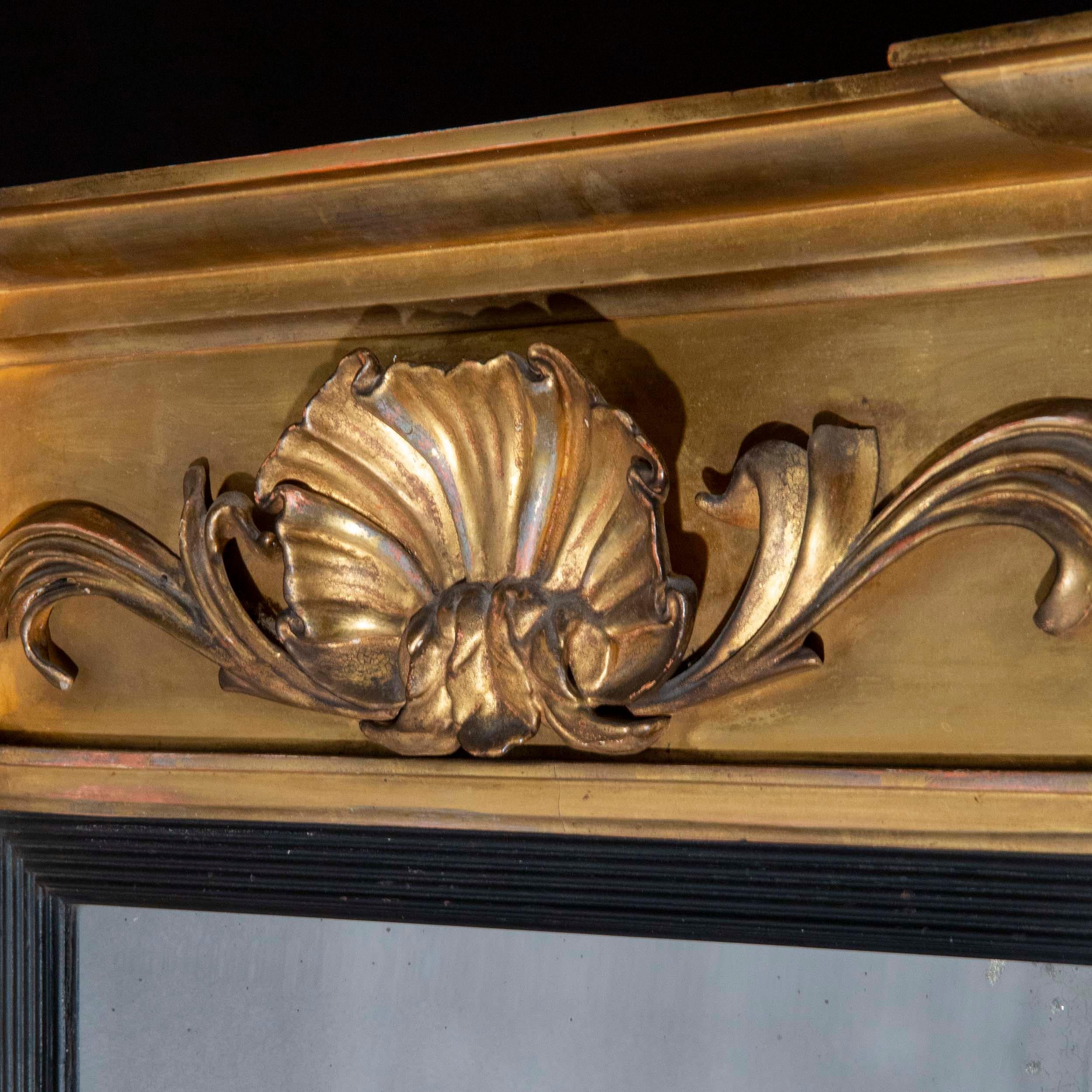 Ein schöner Übermantelspiegel aus dem frühen 19. Jahrhundert aus der Regency-Periode in seinem ursprünglichen Rahmen aus vergoldetem Holz, mit einem exquisit und fein geschnitzten Muschelornament. Sowohl die abgeschrägte Spiegelplatte als auch die
