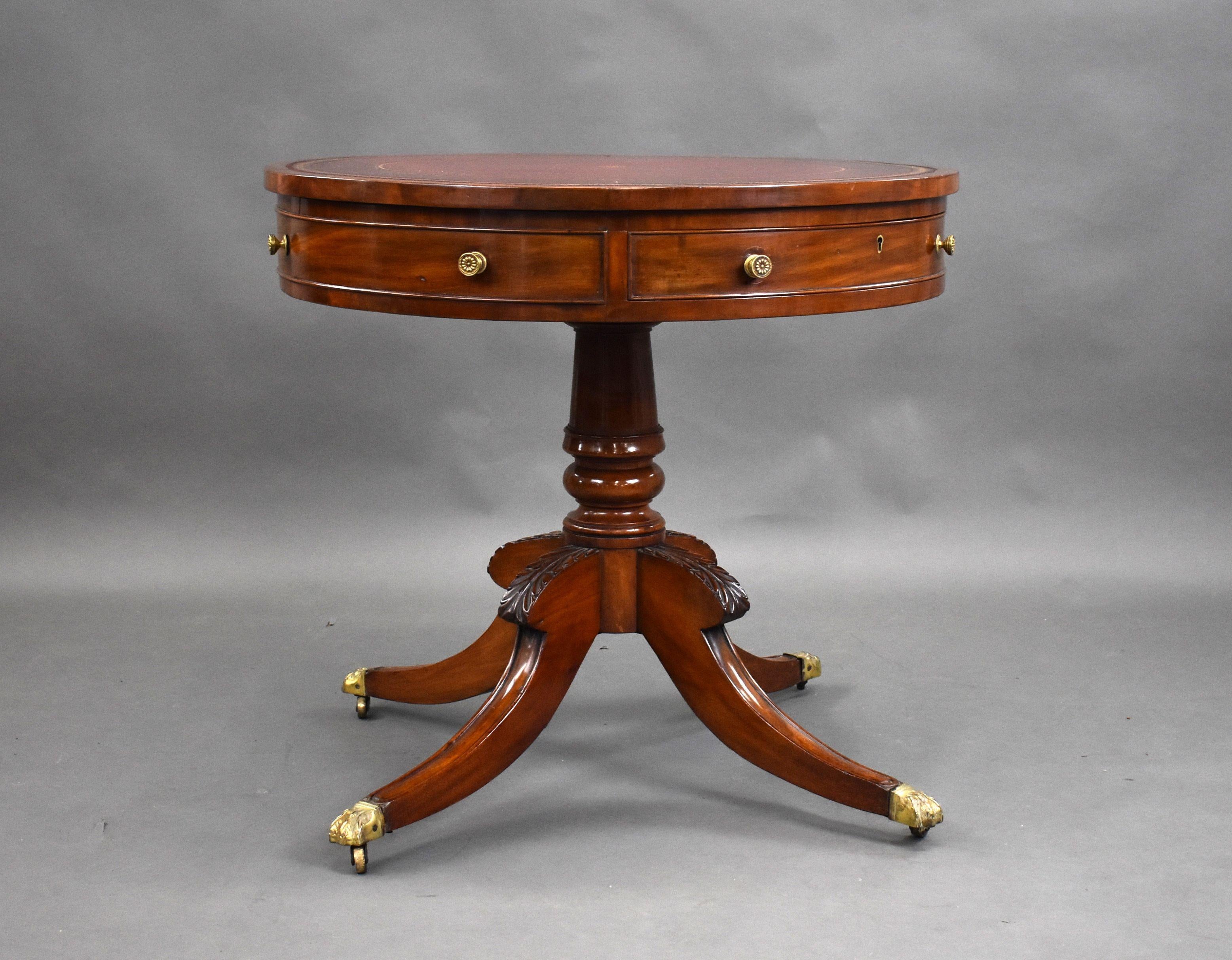 For sale is a fine quality Regency mahogany drum table of small proportions, labelled Druce & Co. Having a red leather top, decorated with gold tooling, the table is fitted with two drawers and two faux drawers above a turned stem standing on