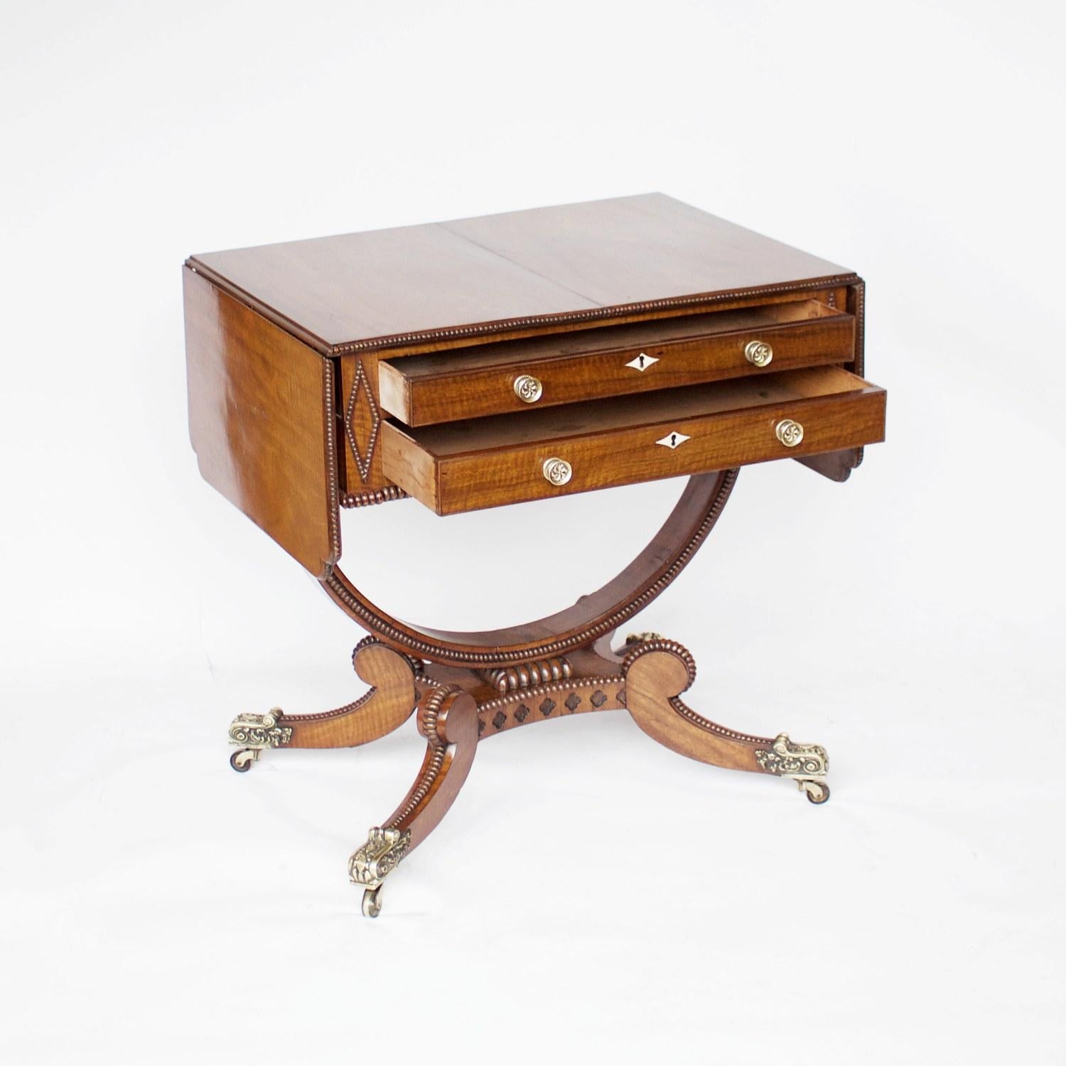 A small Regency sofa table. Rosewood veneered on mahogany with mahogany lined drawers. Bowed, studded stretcher leading to sabre legs with carved brass finials.

Dimensions: H 70.5 cm, D 50.5cm, W 70-125cm

Origin: English

Date: circa 1815.
 