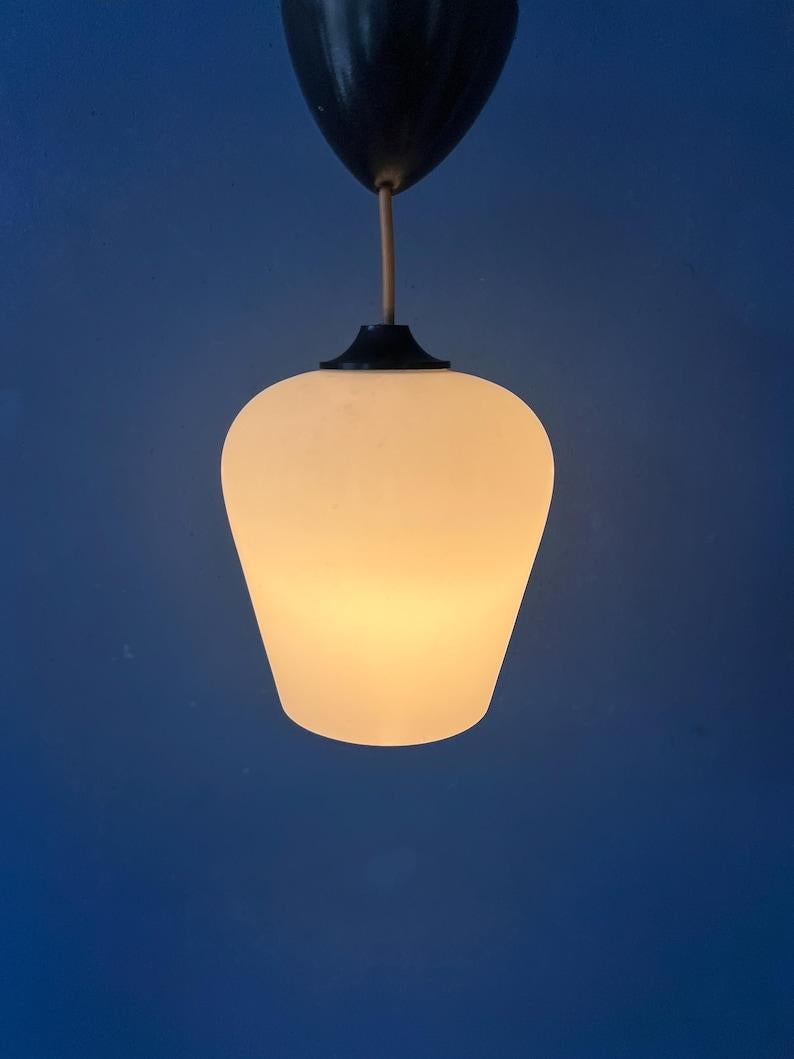 Lampada a sospensione in vetro lattimo in stile scandinavo di metà secolo con tappo da soffitto nero. La lampada ha un paralume in vetro a forma di tulipano rovesciato. Dona una luce piacevole e calda. La lampada richiede una lampadina E27/26