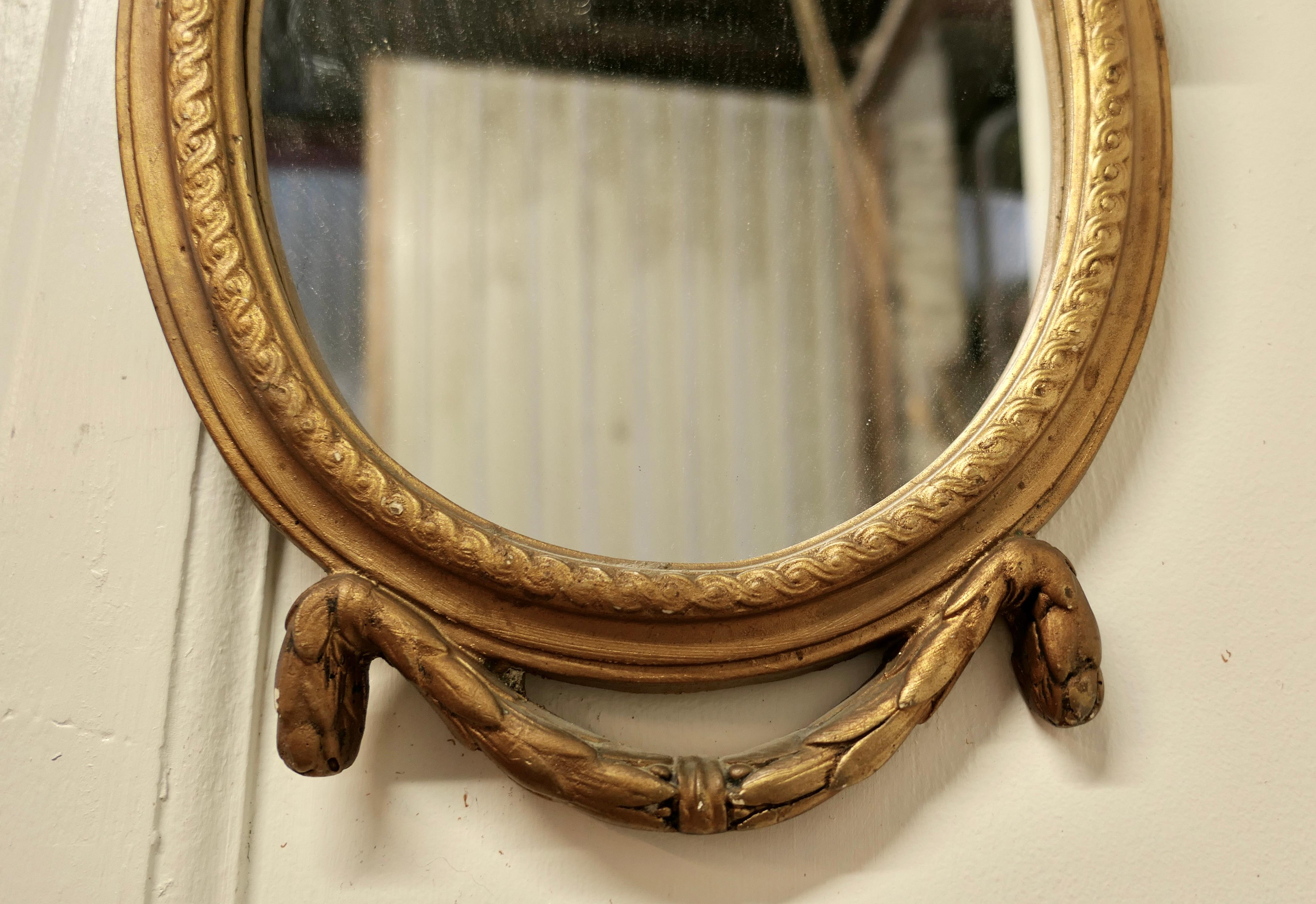 Pequeño espejo de pared rococó oval dorado siglo XIX en venta