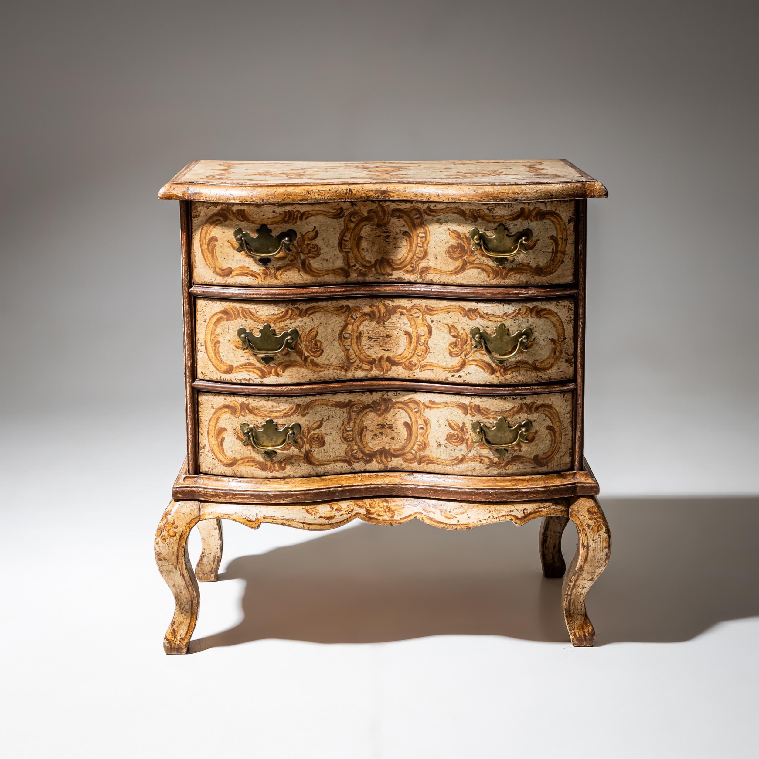 Charmante, handbemalte Kommode im Louis XV-Stil mit schlangenförmiger Front, Schürze mit Wellenschliff und elegant geschwungenen Beinen. Die neu aufgetragene beigefarbene Oberfläche ist mit zarten Rokoko-Motiven wie Zierkartuschen und stilisierten