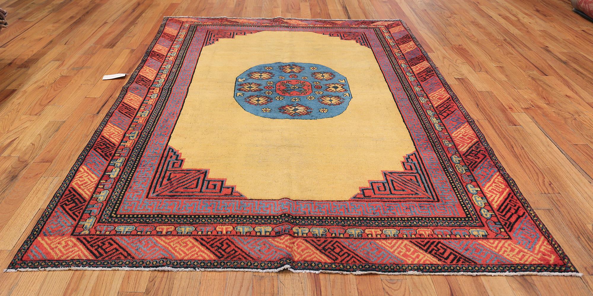 Funky Small  Size Tribal Antique Khotan Rug, Country of Origin / Rug Type: East Turkestan Rug, Circa Date: First Quarter of the 20th Century – A delightful showpiece of vivid colors and bold shapes, this antique Khotan rug centers around a rounded,