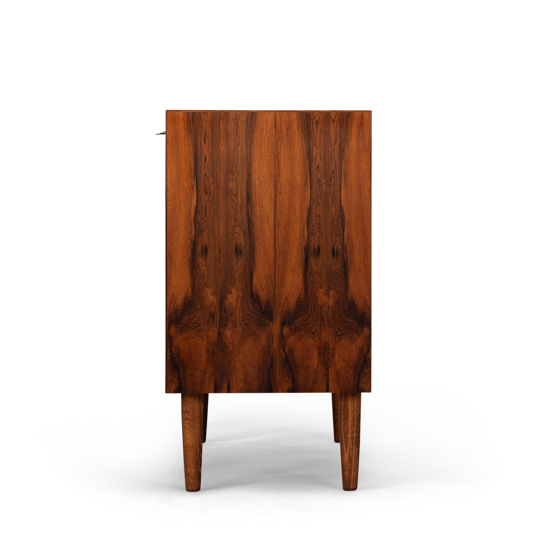 Danish Design : Chest of Drawers
Introducing an exquisite vintage chest of drawers from the 1960s, a true embodiment of timeless design and craftsmanship. This piece, a harmonious collaboration between renowned designer Erik Jensen and esteemed