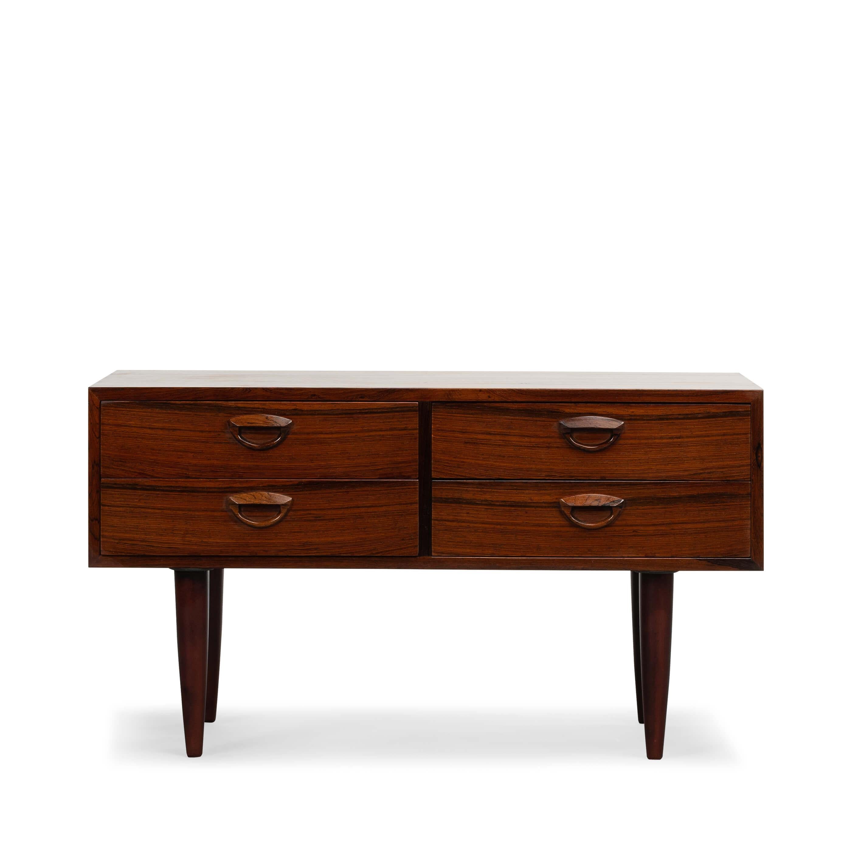 Danish Design by Kai Kristiansen
This stylish chest of drawers was designed by Kai Kristiansen and produced by Feldballes Møbelfabrik in the 1960s. 

This cabinet is made of rosewood and has beautiful detailed lines with his signature eyelid