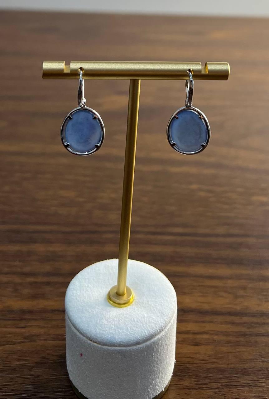 Earrings featuring round faceted blue lapis lazulis encircled by a halo of diamonds. Set in 14k gold. Total carat weight of primary stones: 11.75. Diamond accents: 0.25 carats. 14.5x12x4.5mm Sizes,