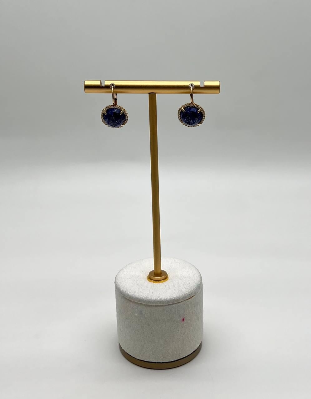 A study in elegance, depth, and shimmer.

These captivating earrings feature stunning deep blue lapis lazuli 10MM stones, each encircled by a halo of sparkling diamonds. The round stones are set in 14k gold, creating a striking contrast that