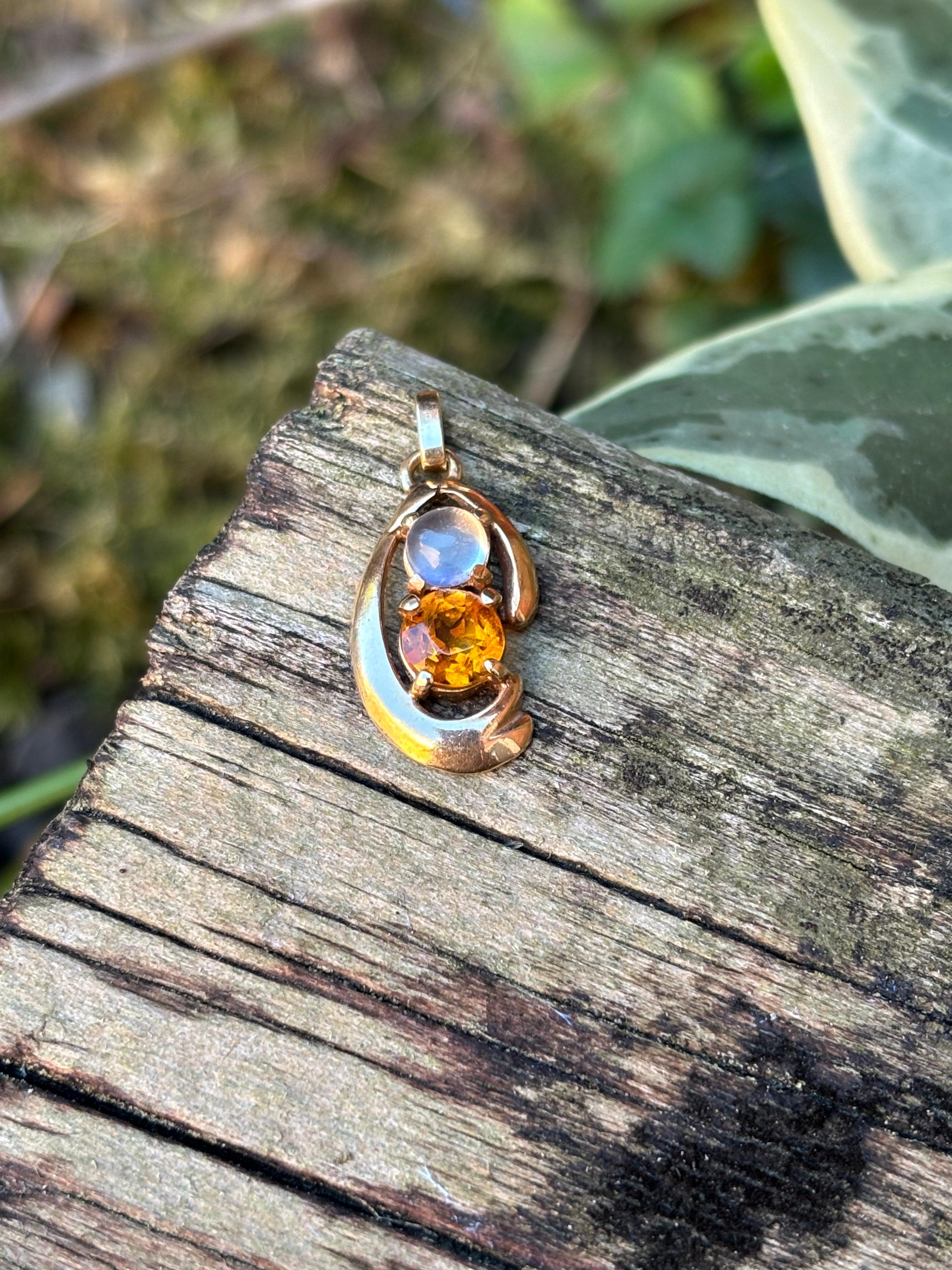 Cet élégant pendentif vintage présente une combinaison harmonieuse de pierres précieuses lumineuses serties dans de l'or jaune 14 carats. En son centre repose une citrine dorée de taille ronde, rayonnant d'un éclat ardent et captant la lumière à