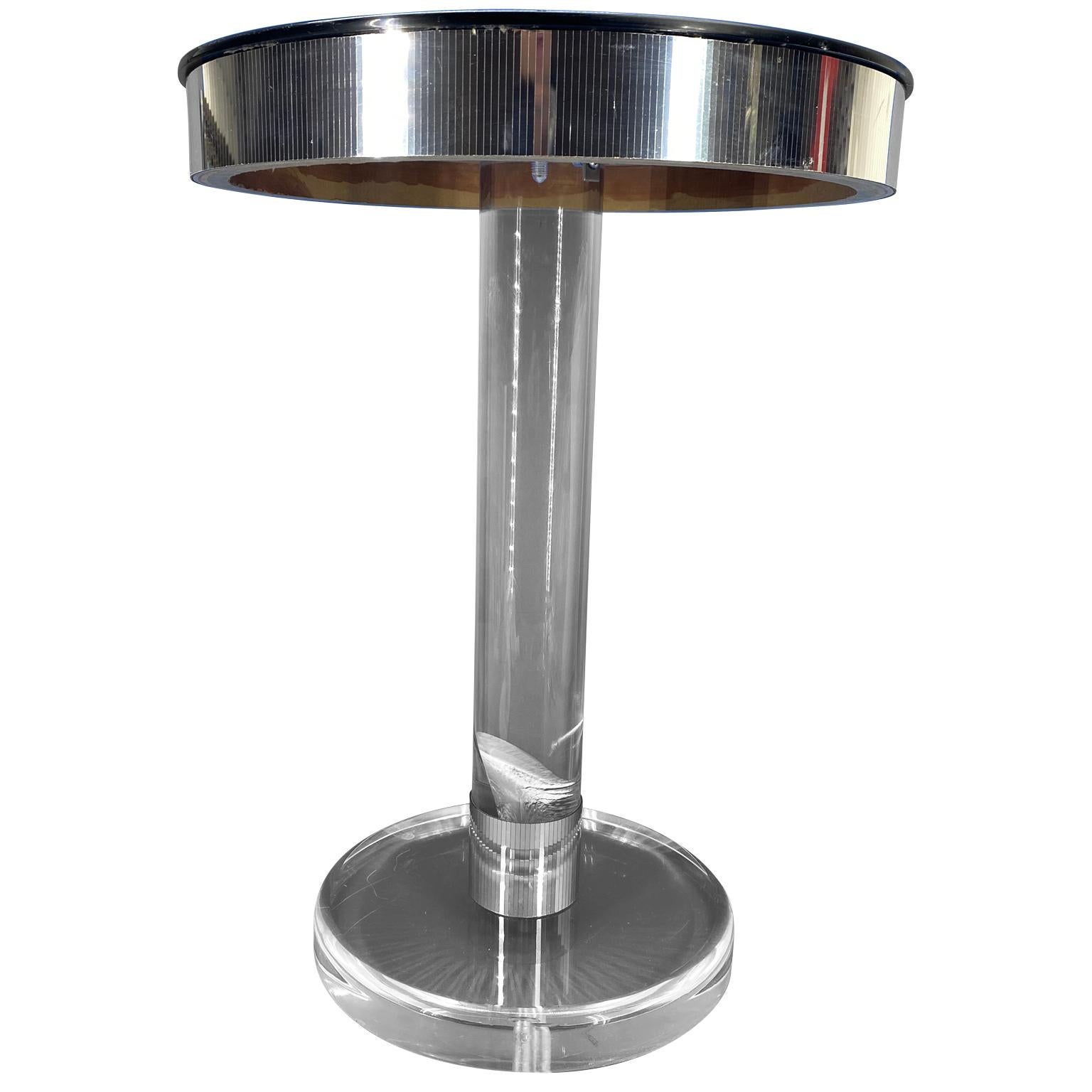 Small round midcentury Lucite side table with black glass top and with reflective chrome accents around the tabletop.



   