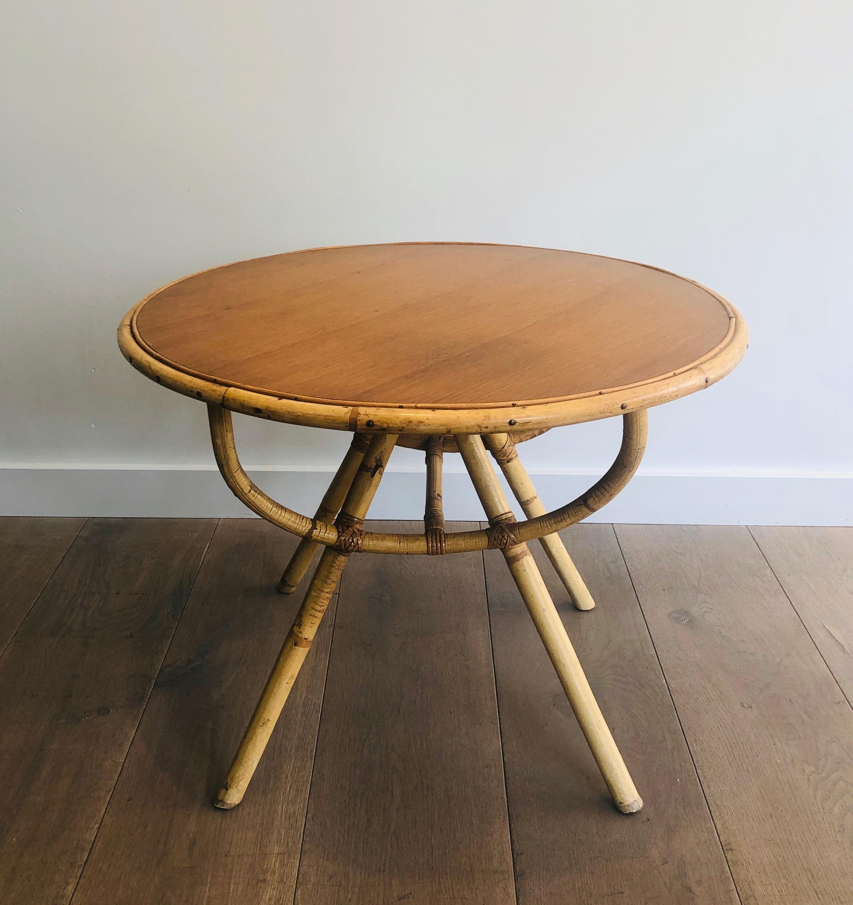 This nice small round coffee table is all made of rattan with a wooden top. This is French work, circa 1970.