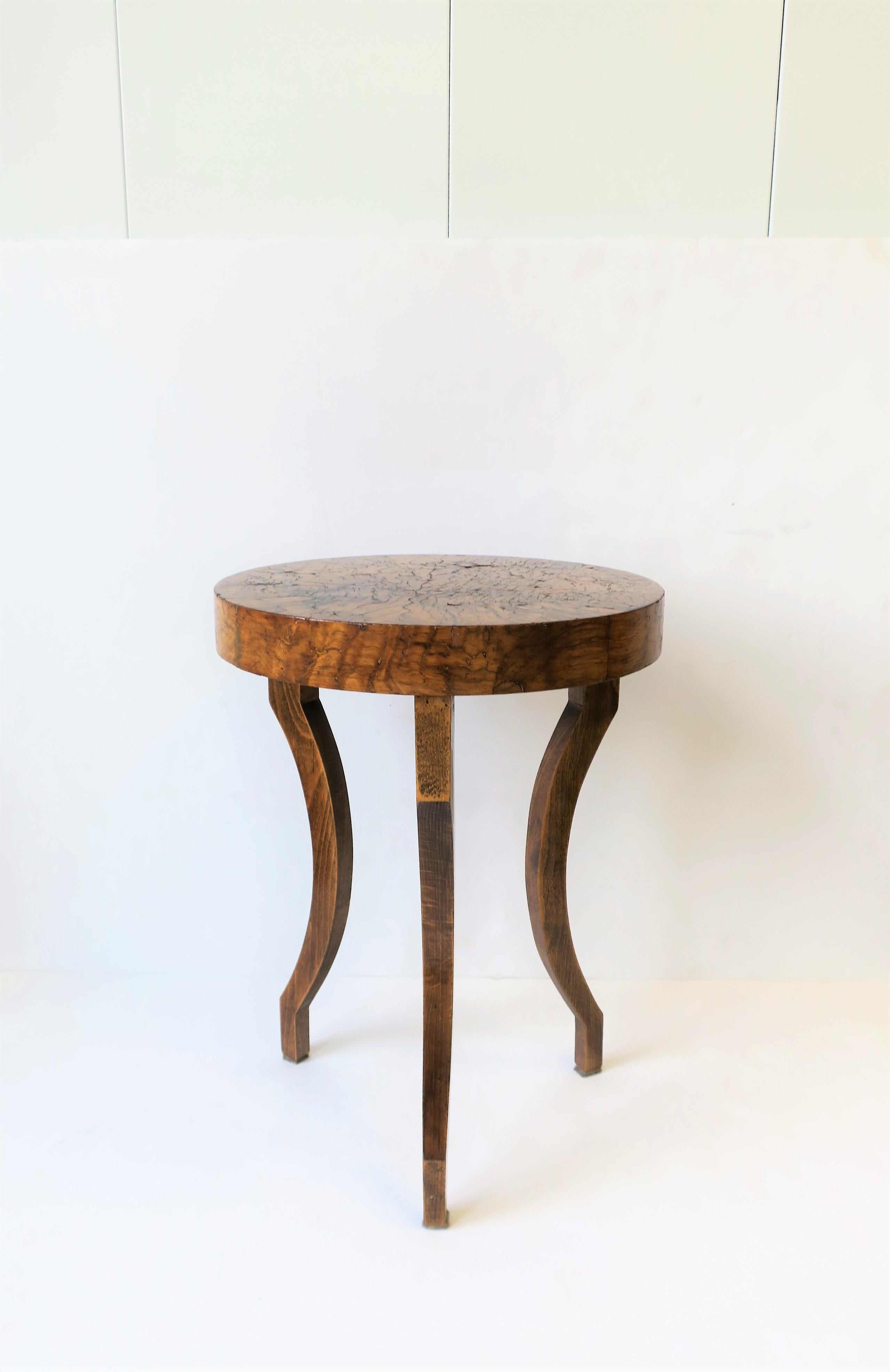 A small rich wood gueridon side or drinks tables with decorative legs. Tabletop and sides may be a burl or fruitwood veneer. 

Table measures: 13.75 in. Diameter x 18.5 in. H.
   