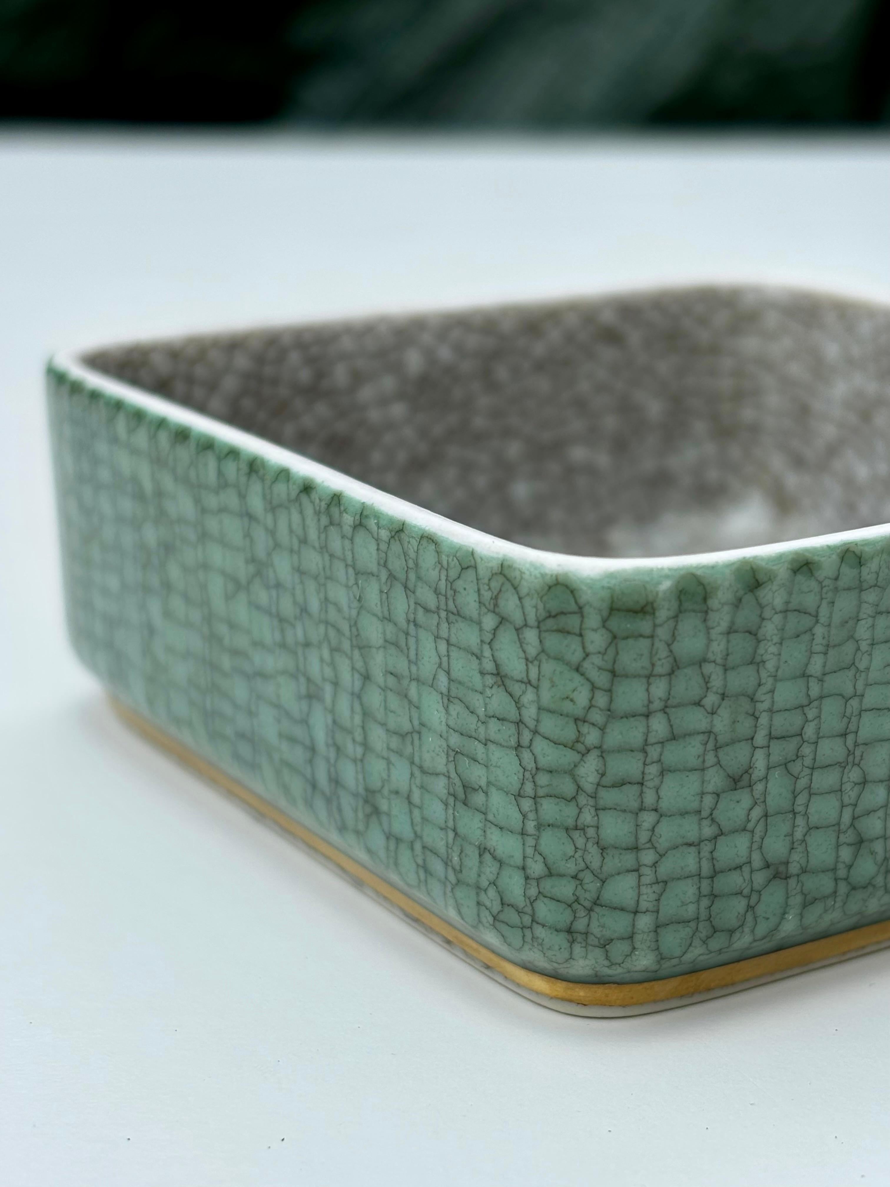 Vintage Royal Copenhagen porcelain vide-poche dish with green and gray colored crackle glaze and simple decorative golden band base. Signed, stamped and numbered under base.
Beautiful, seemingly unused vintage condition. 
Denmark, 1950s.