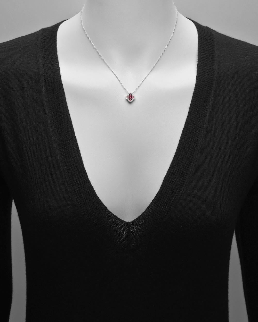 Clover pendant with ruby center and diamond frame, in 18k white gold. Five rubies weighing 0.99 total carats and 28 diamonds weighing 0.15 total carats. On a 17