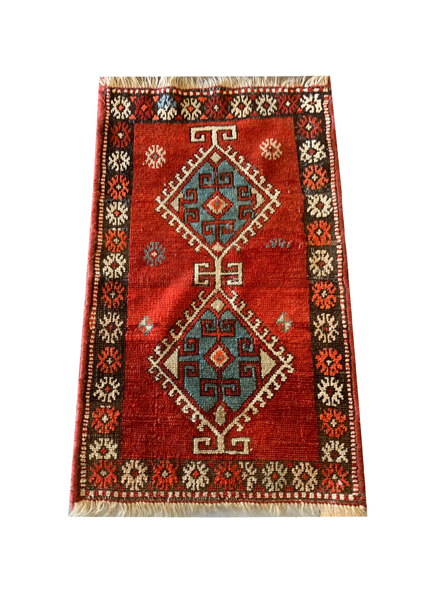 This fine red small wool rug features a tribal design with central diamond medallions woven on a red field in accents of beige and blue. The bold design and colour palette make this a great accent piece. The craftsmanship is evident in both the